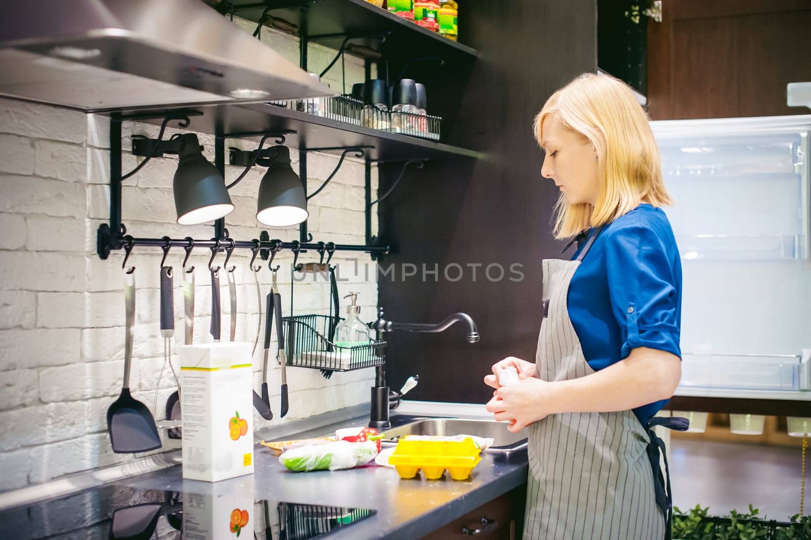 woman with shopping bags parses the kitchen. housewife in apron in the kitchen arranges bought food