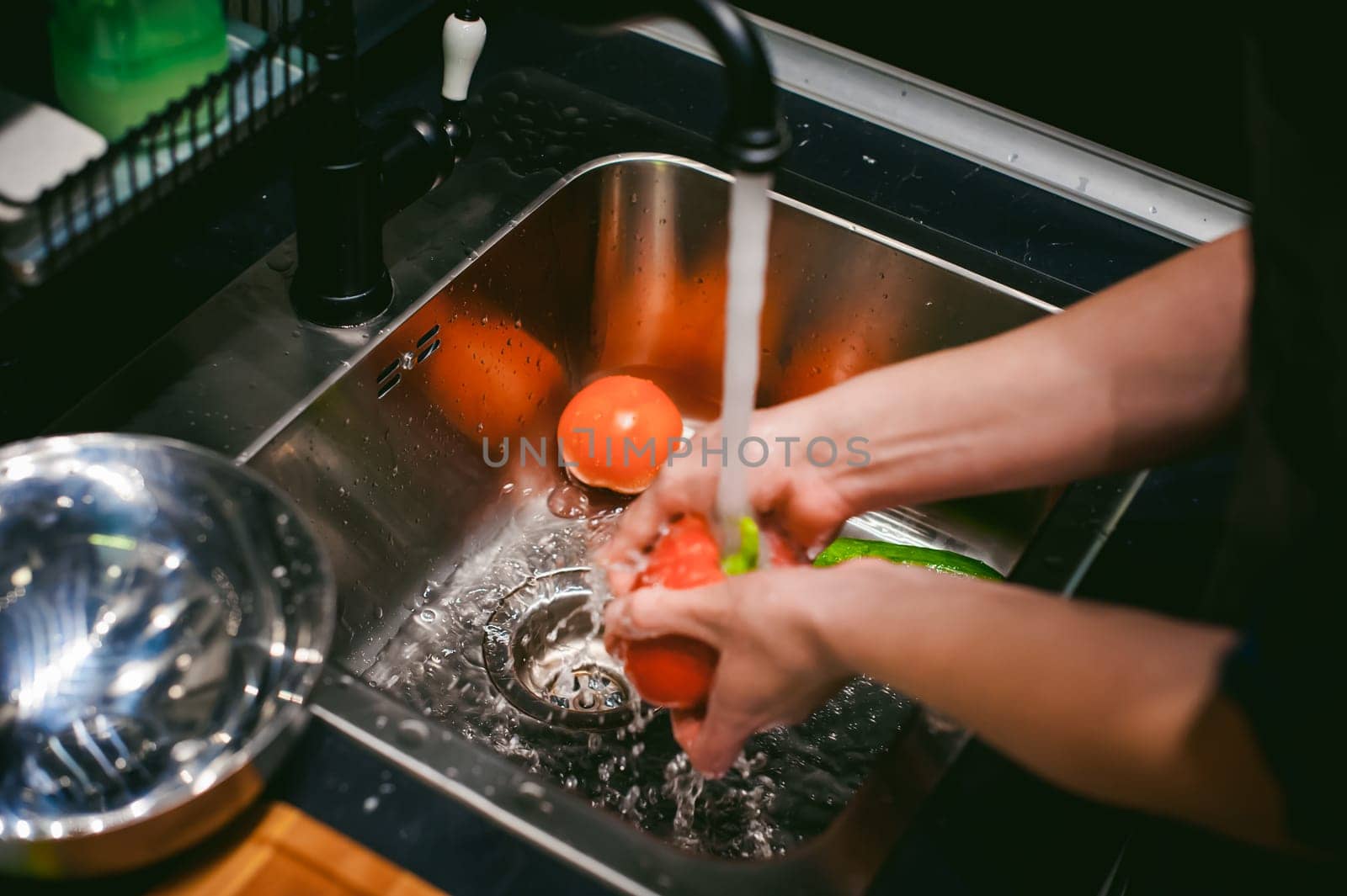 woman washing vegetables for cooking, water under the tap