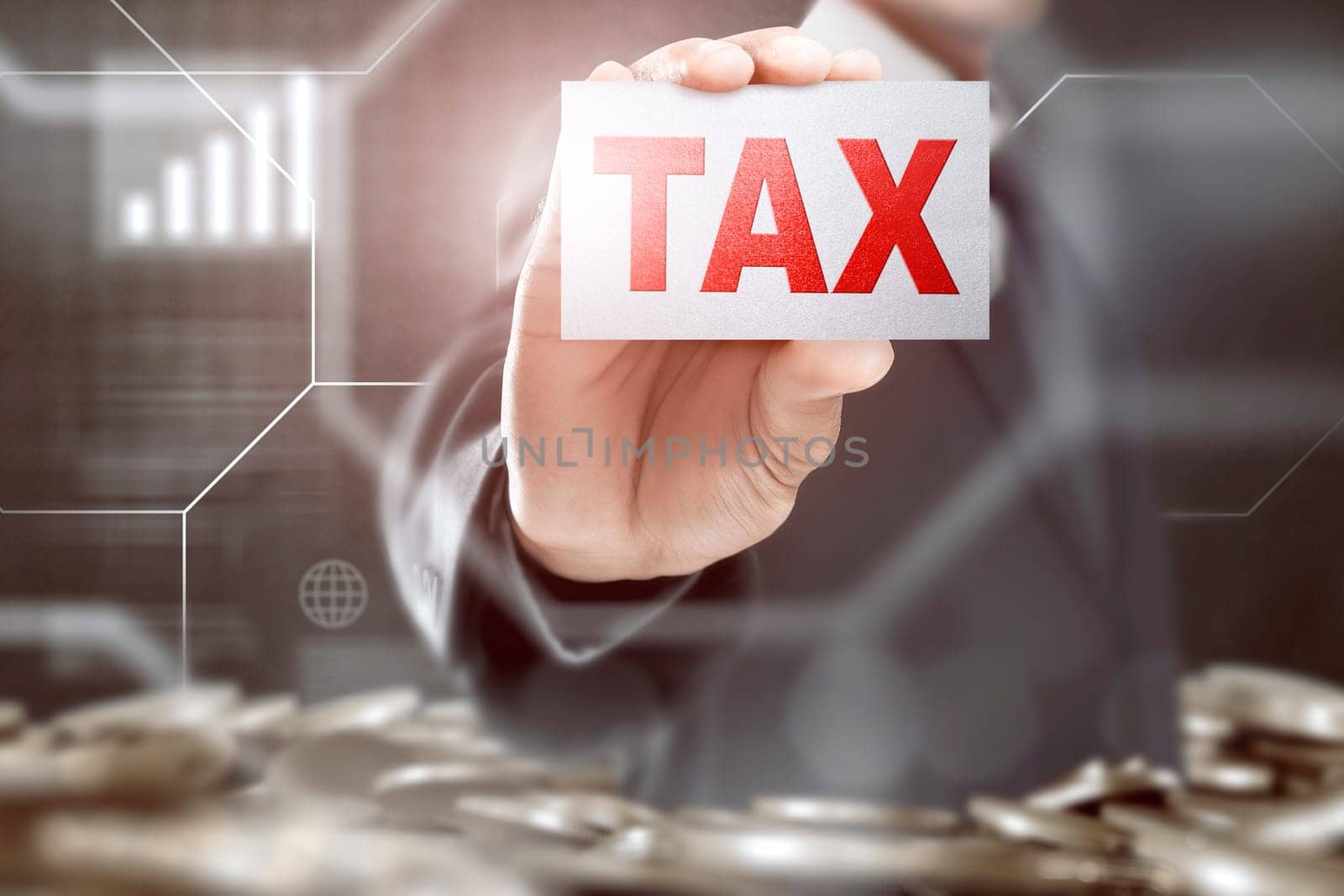 Businessman showing a card with Tax sign on coins pile background