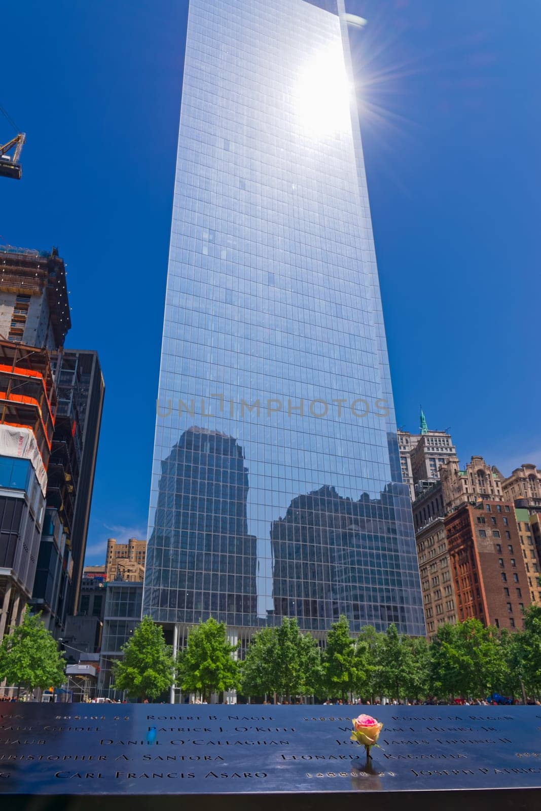 New York, USA - June 08, 2015: South pool memorial commemorating the victims of the 11 september terror attack in 2001. New York architecture in the background.