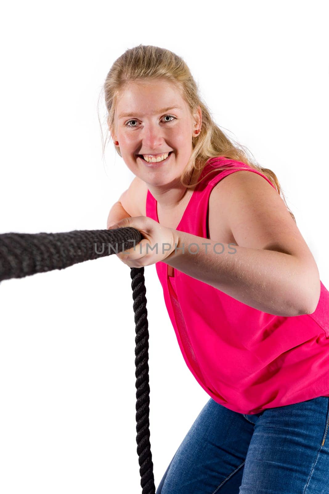 Young woman with red T-shirt and jeans pulls on a rope