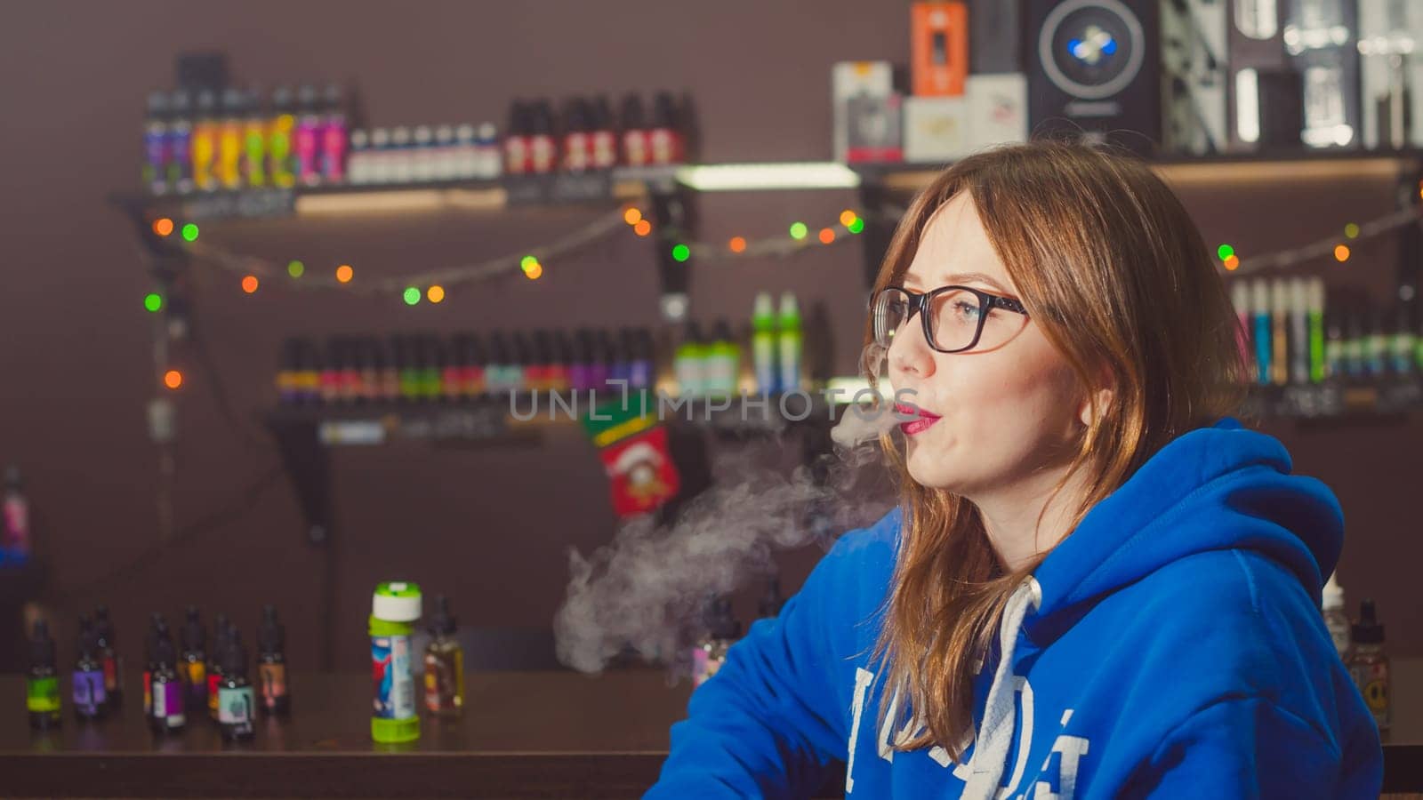 beautiful young woman with glasses smoking electronic cigarette