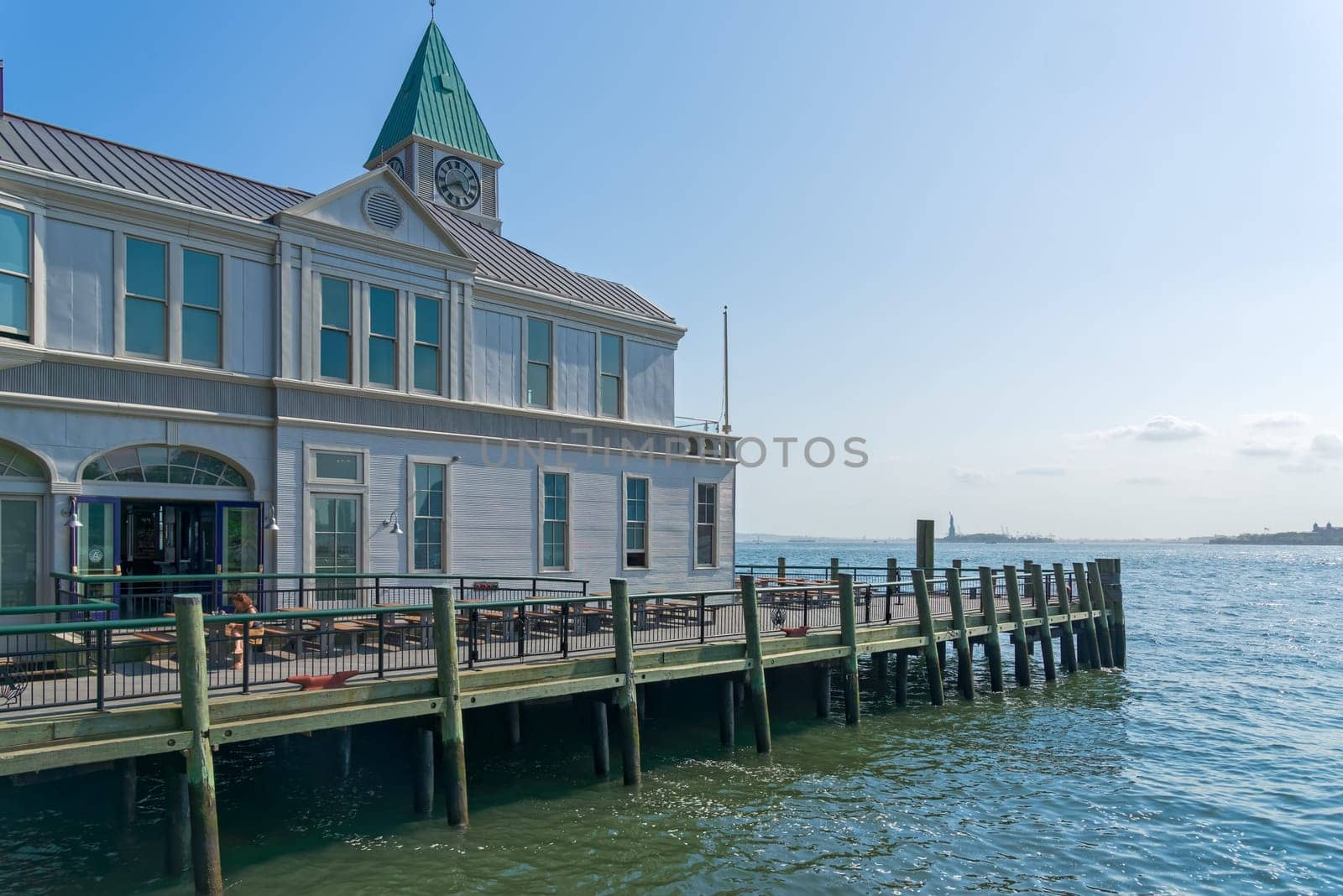 New York, NY, USA - June 06, 2015: Pier A Harbor House with restaurant situated on the Hudson River at Battery Park, Lower Manhattan. Modern skyscrapers in the background. Blue sky.
