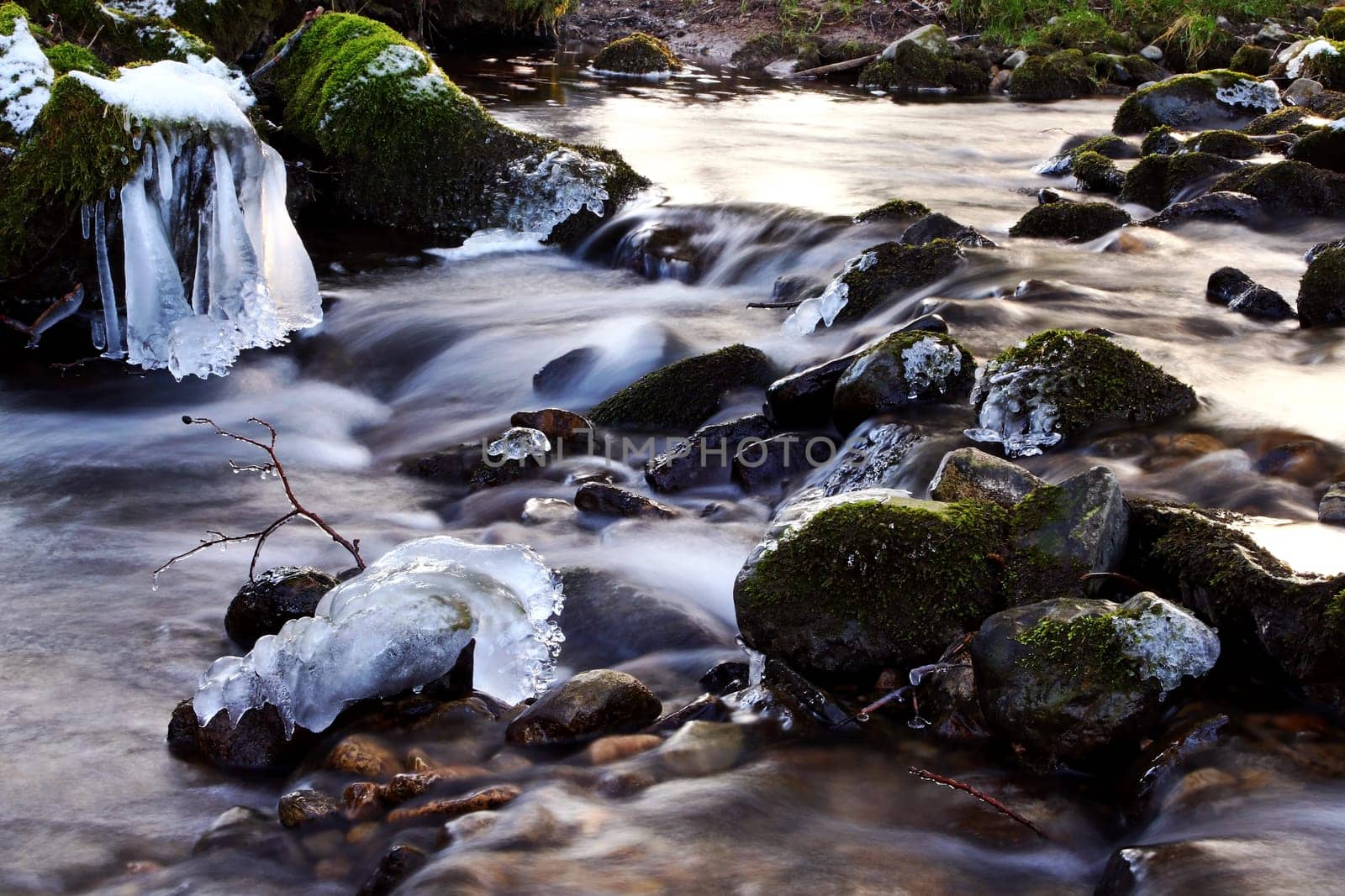 A frozen stream in winter. Frozen stream with icicles in long exposure