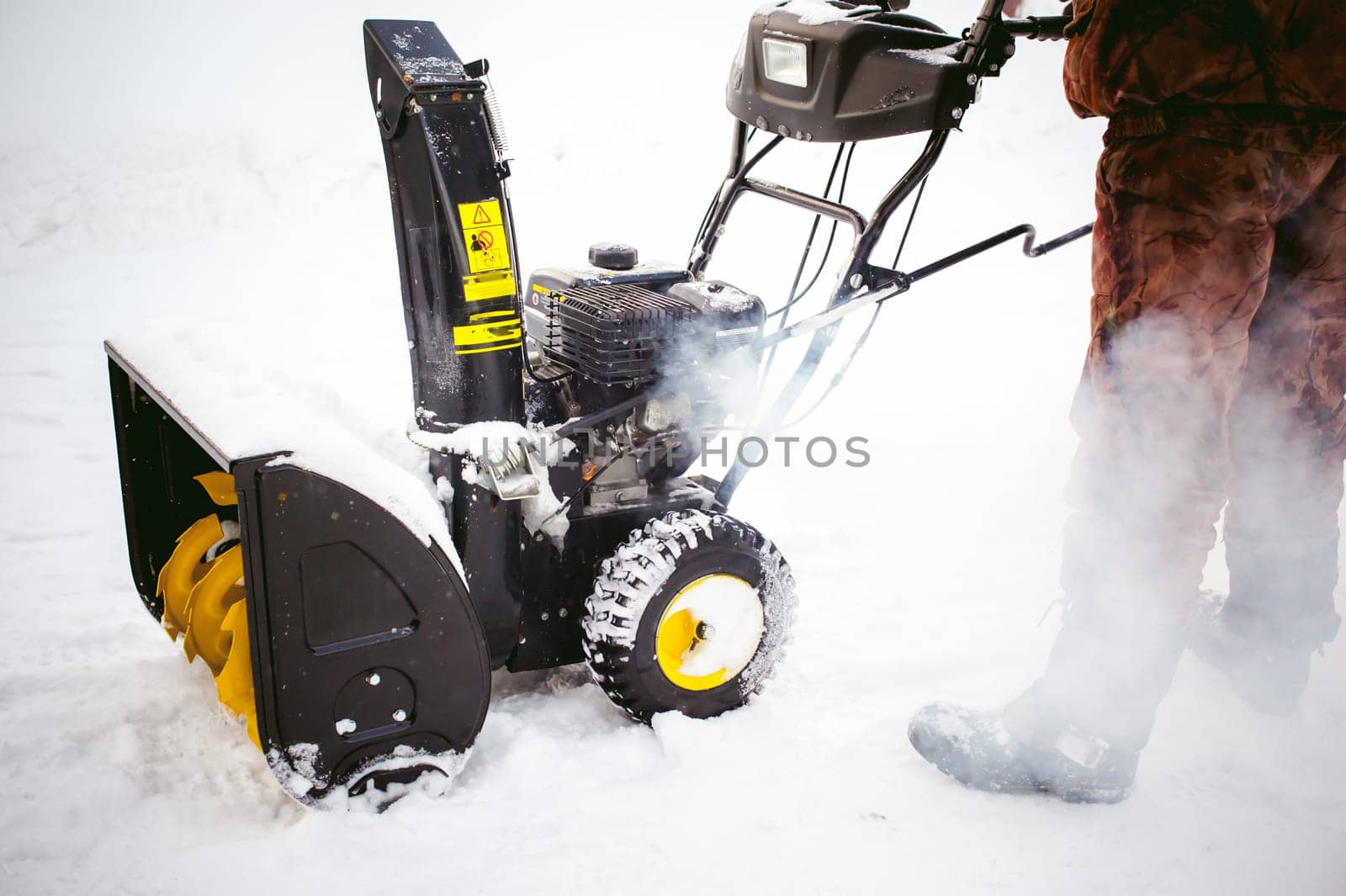 man starts the engine snow blower