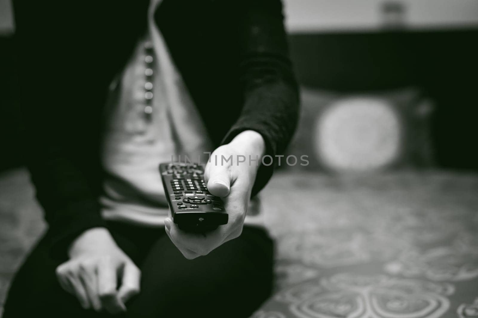 girl in a home environment, holding a TV remote, switching channels