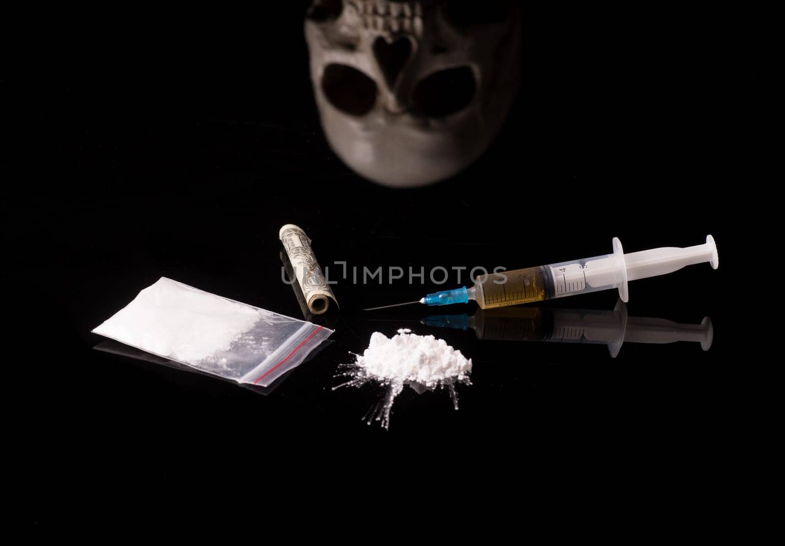 cocaine, Herion or other illegal drugs that are sniffed by means of a tube or injected with a syringe isolated on black glossy background