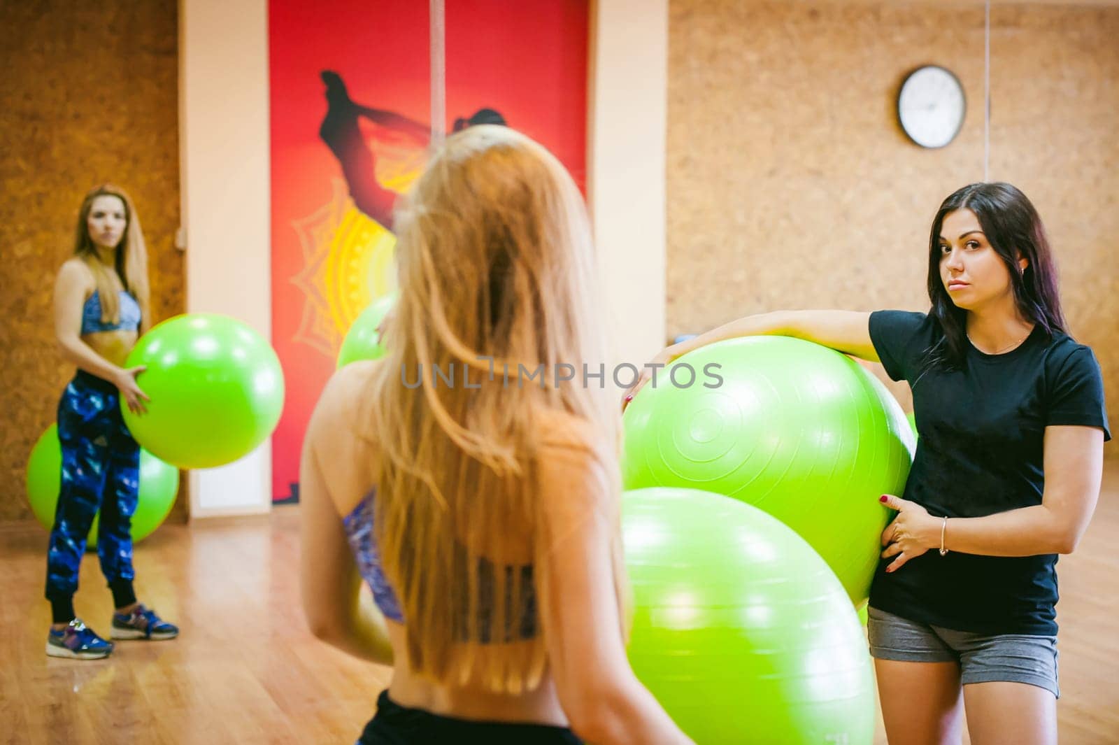 Two young athletic physique women in gym. Fitness girl with fruits, lifestyle in losing weight and diets, proper nutrition, exercise