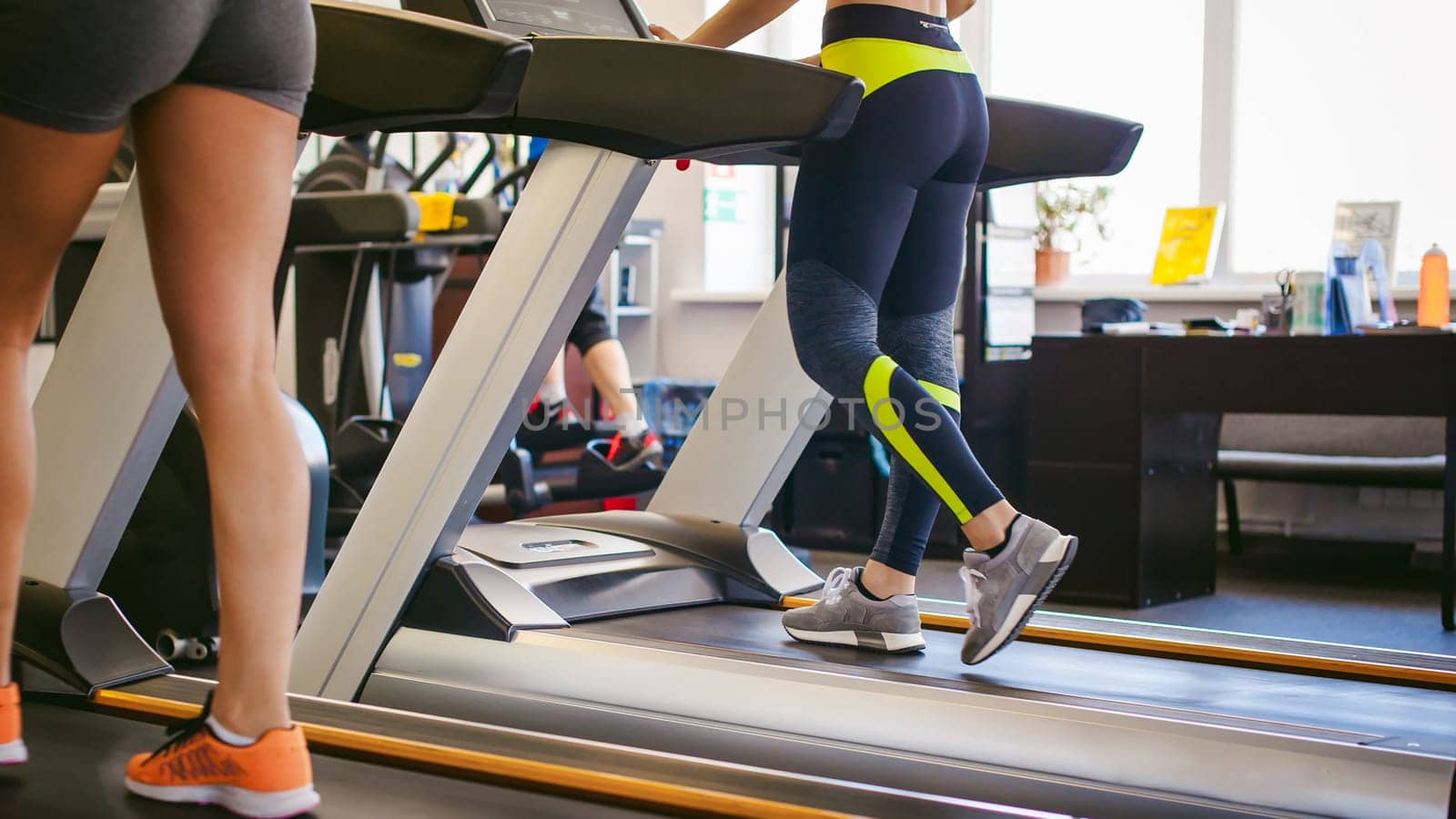 young woman is engaged fitness in gym. Performs cardio load on treadmill, running and walking with acceleration. sport, fit, lifestyle, technology and people concept