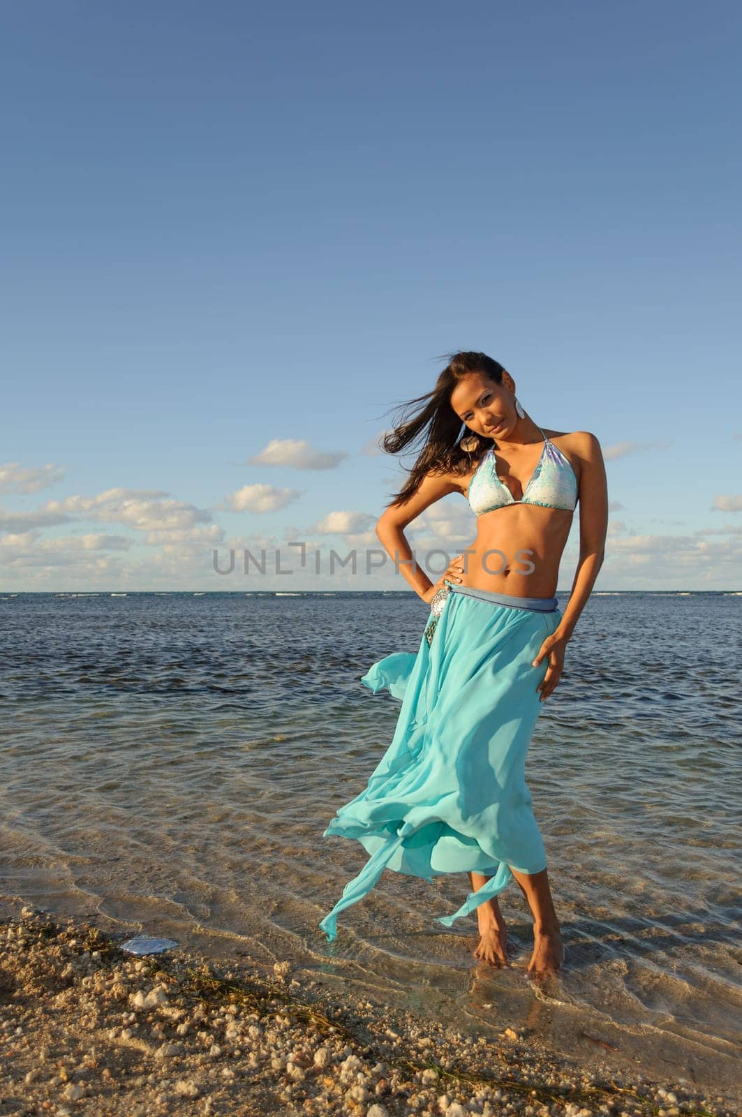 Beautiful and sexy girl posing at the beach in dominican republic dressing bikini and a turquoise skirt