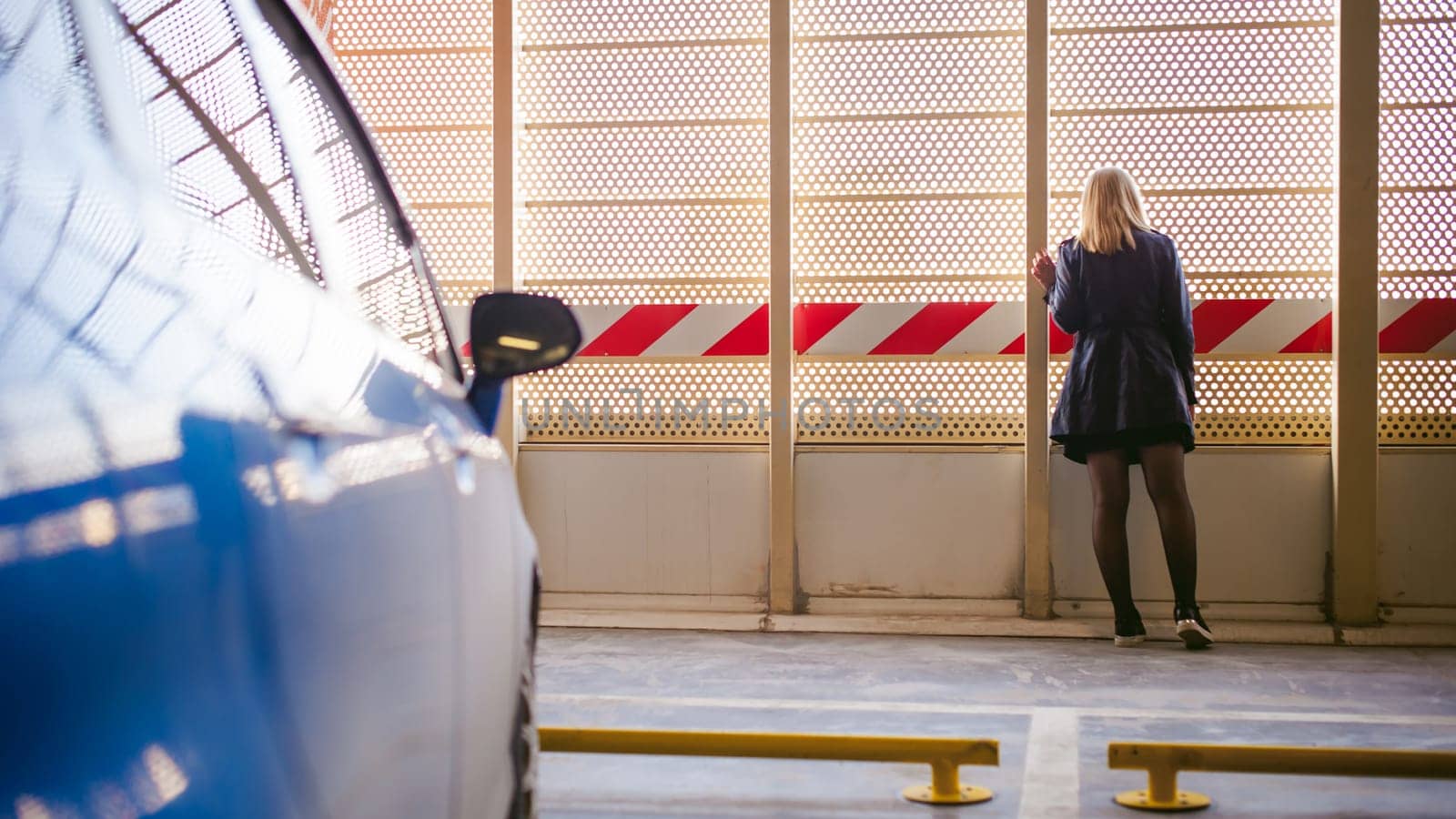 Woman in parking lot on blue car background