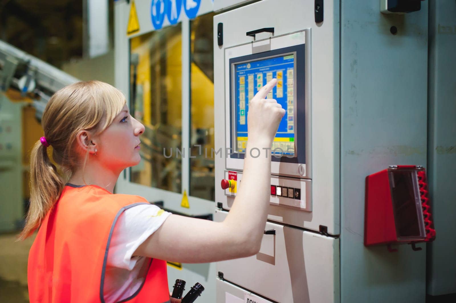 Female worker on beer factory. portrait woman in robe, standing on background line Food production, Inspection management control Equipment for production and bottling finish product end-user buyer