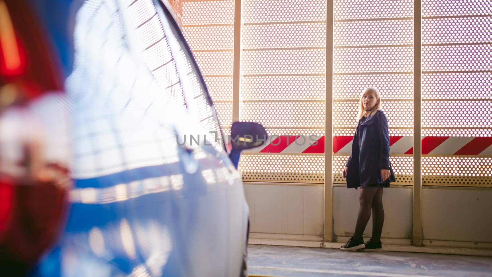 Woman in parking lot on blue car background
