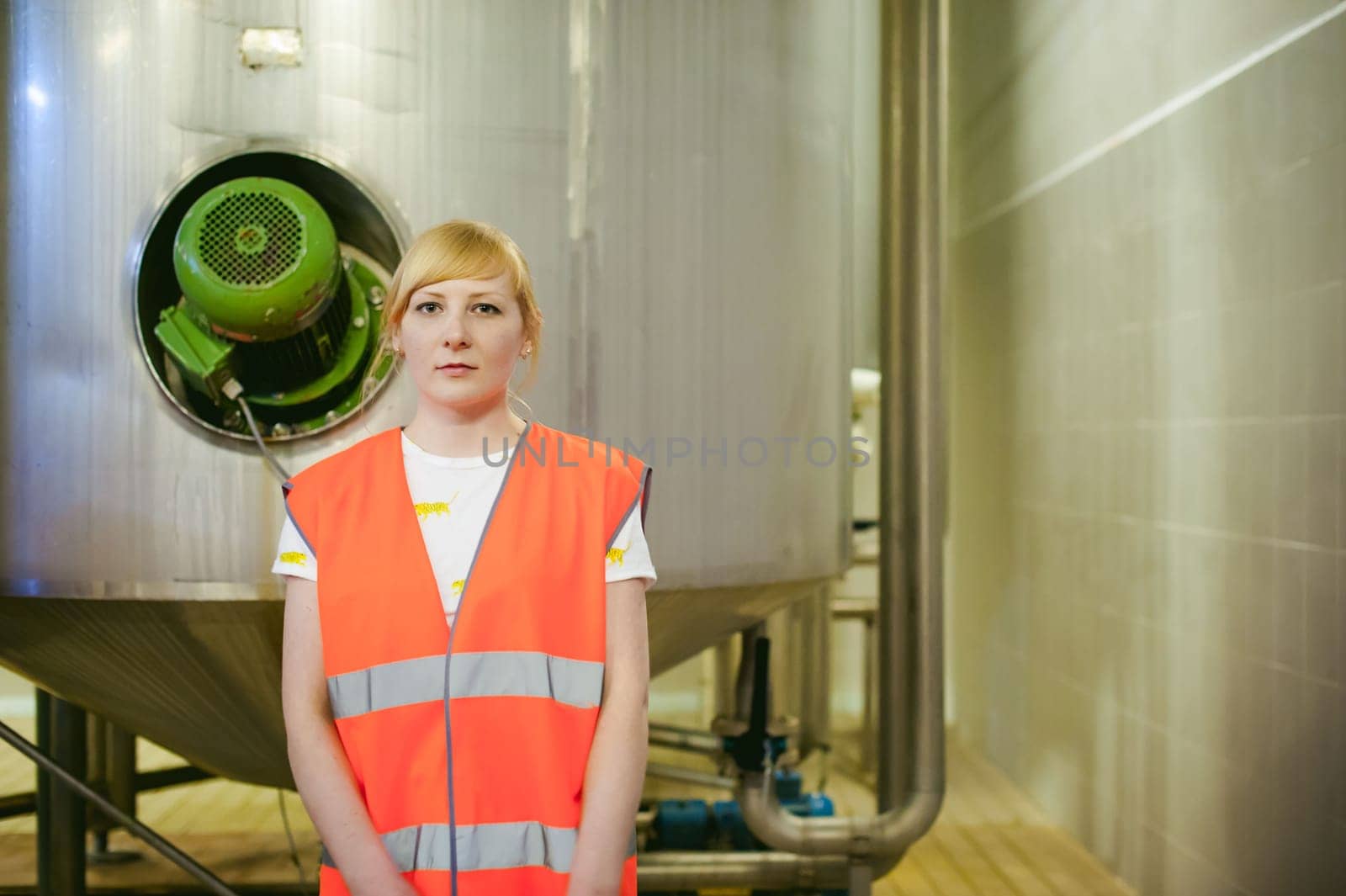 Female worker on beer factory. portrait woman in robe, standing on background line Food production, Inspection management control Equipment for production and bottling finish product end-user buyer