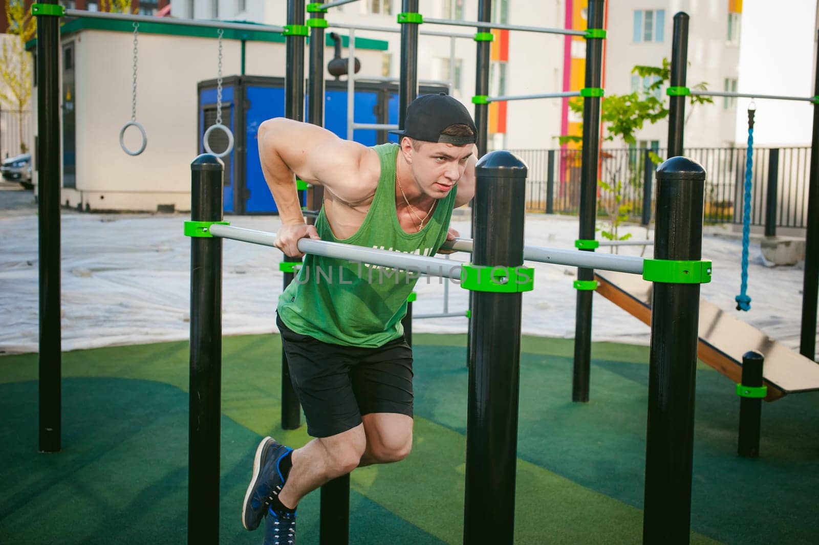 Handsome sexy male bodybuilder athlete man doing crossfit workout in athletic facilities on sunny morning outdoors. Healthy lifestyle concept. Physical preparation of the body