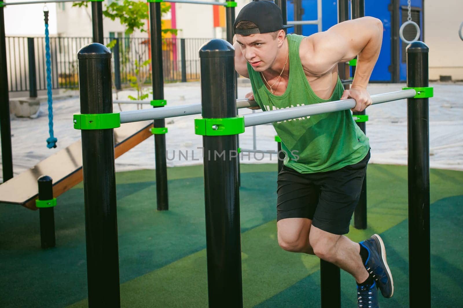 Handsome sexy male bodybuilder athlete man doing crossfit workout in athletic facilities on sunny morning outdoors. Healthy lifestyle concept. Physical preparation of the body