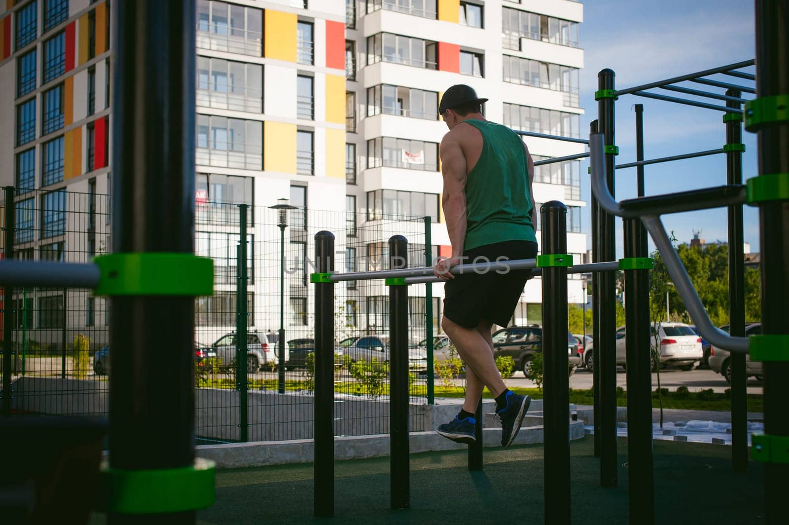 Handsome sexy male bodybuilder athlete man doing crossfit workout in athletic facilities on sunny morning outdoors. Healthy lifestyle concept. Physical preparation of the body