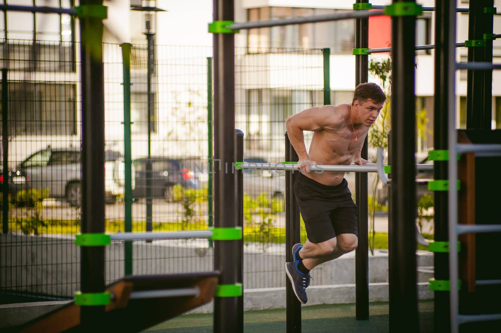 Handsome sexy male bodybuilder athlete man doing crossfit workout in athletic facilities on sunny morning outdoors. Healthy lifestyle concept.
