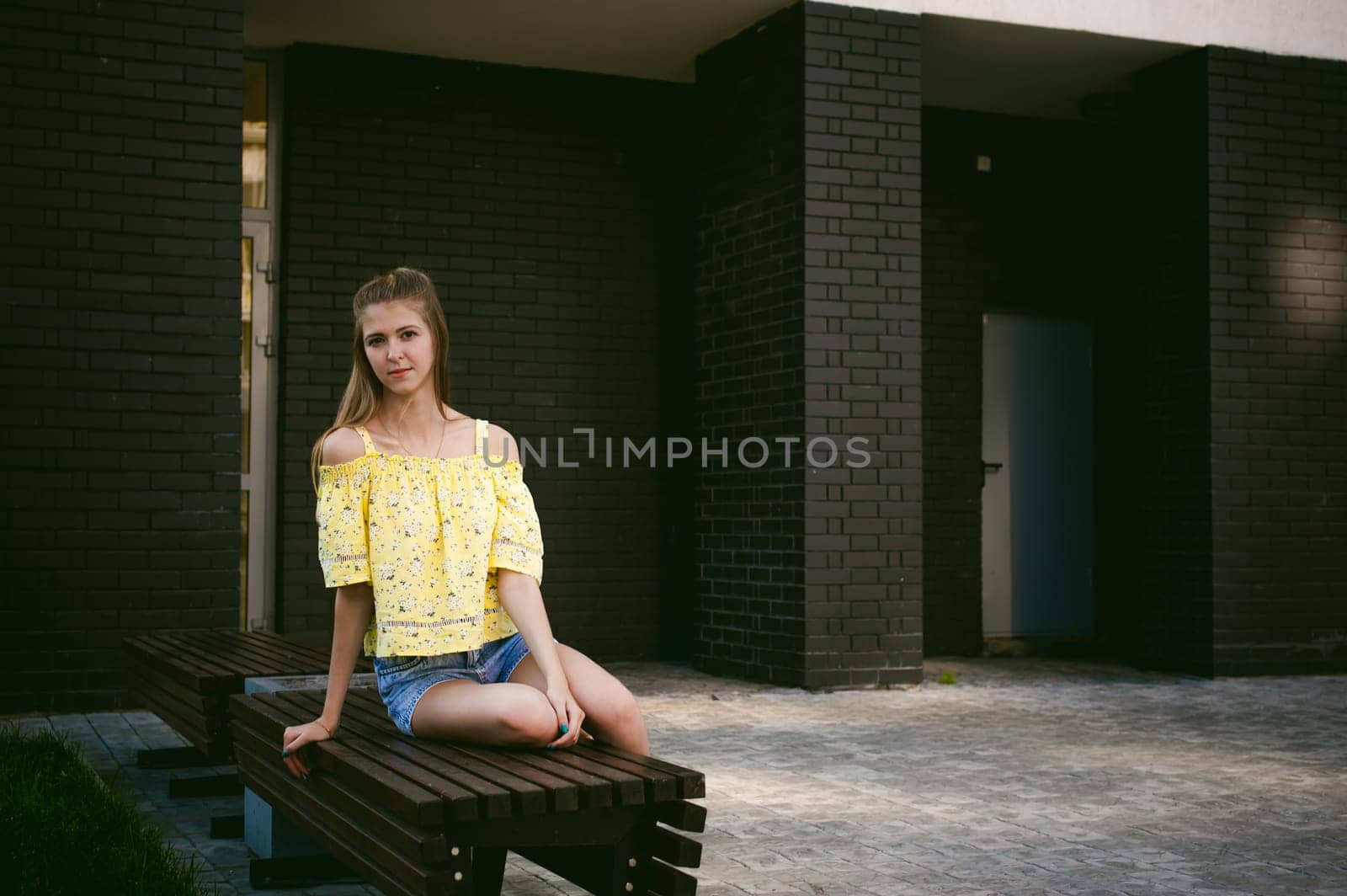 pretty cute young woman posing against the wall of black brick