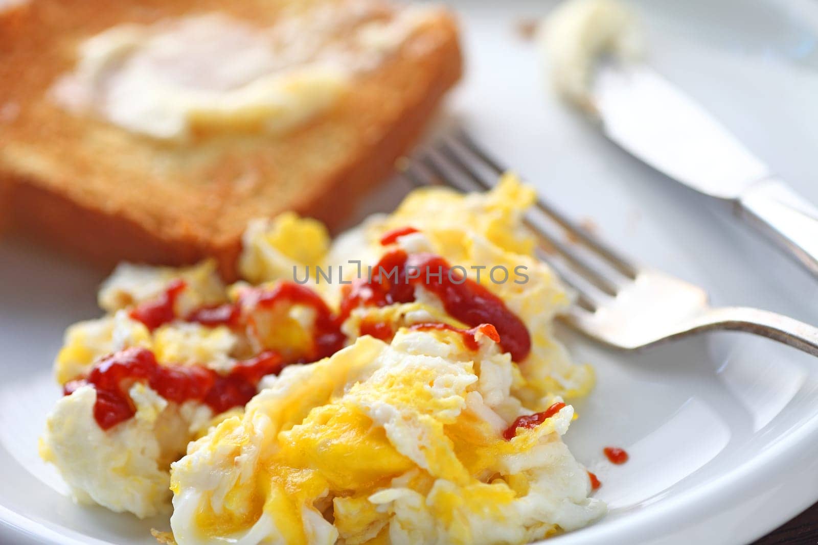 Scrambled eggs with Sriracha hot chili sauce and buttered toast