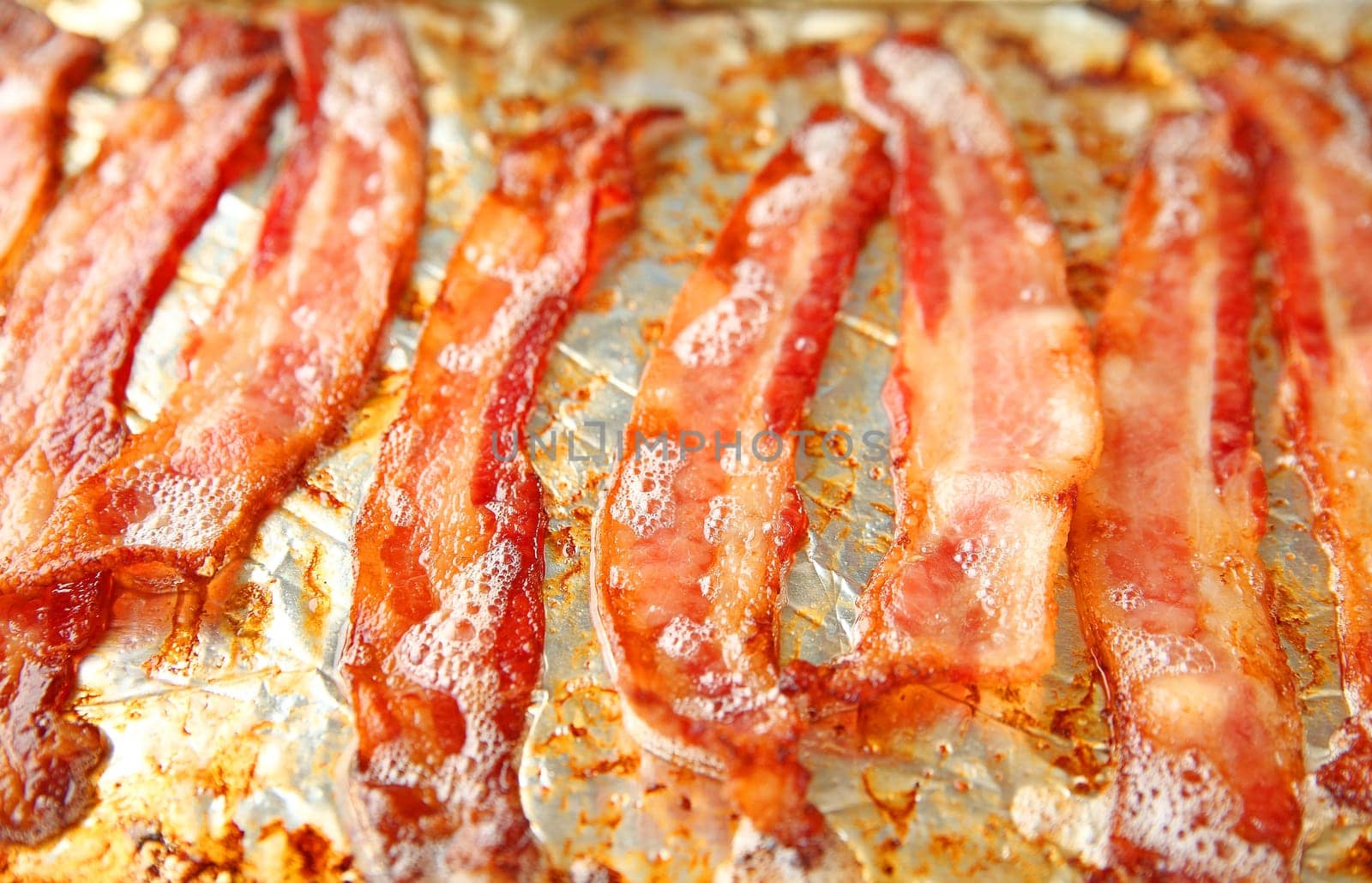 Just removed from the oven, bacon continues to sizzle in the pan.