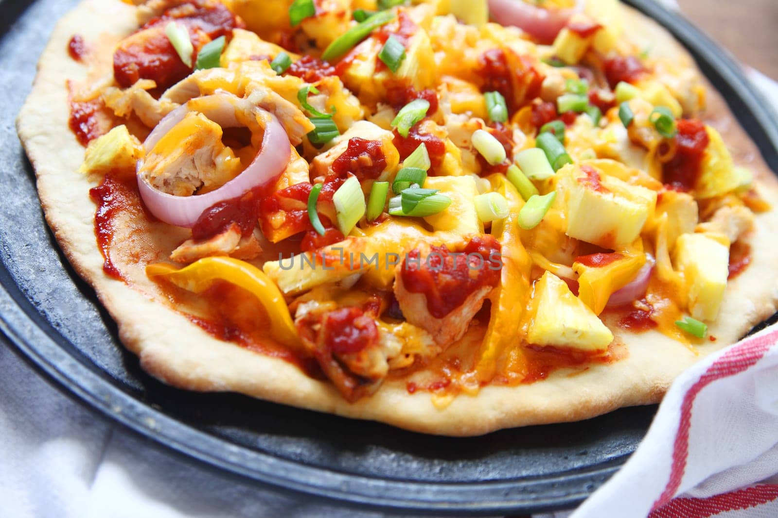 Homemade pizza with chicken, onions, bell peppers, scallions, cheese and barbecue sauce