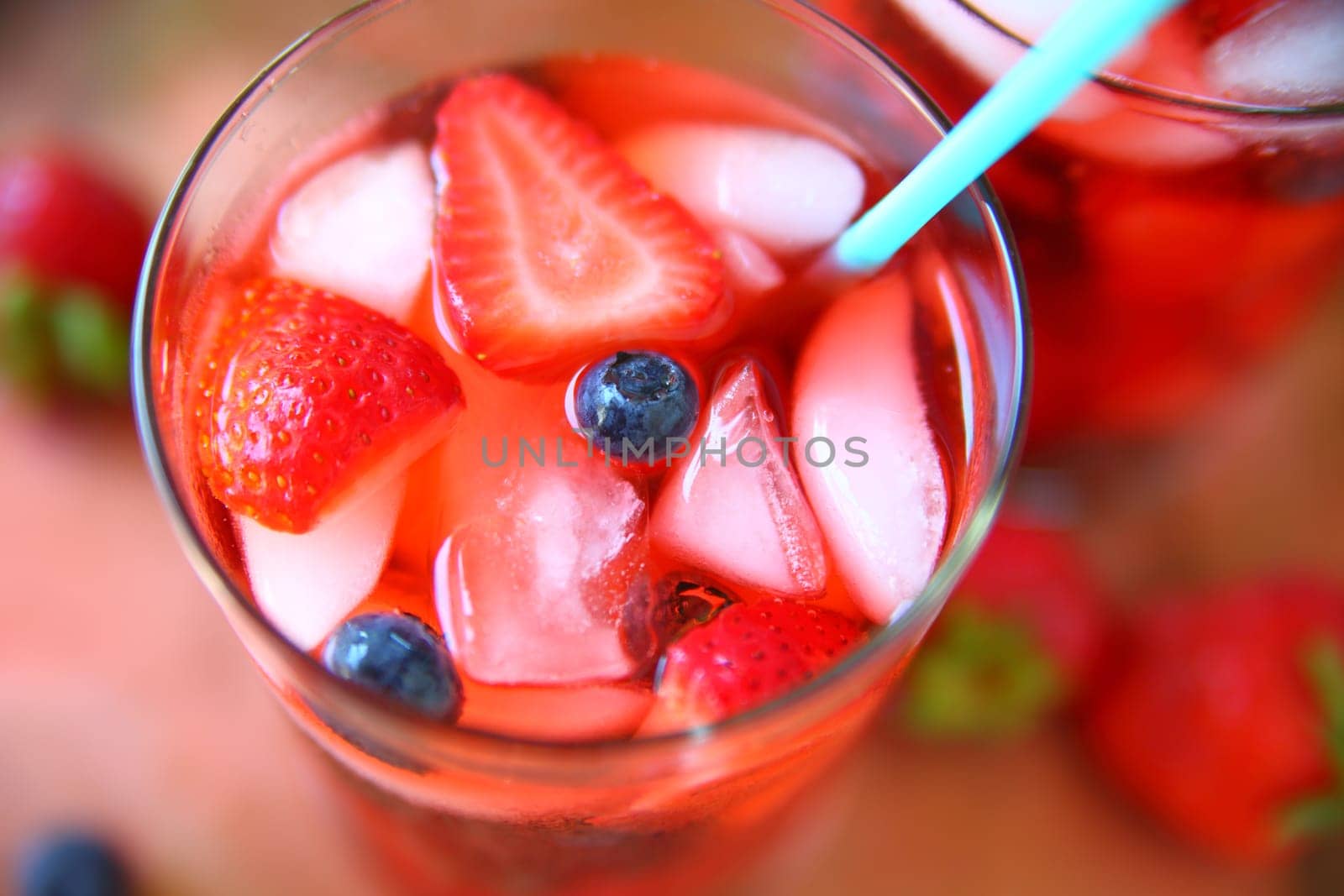 Overhead view of a healthy drink of water, blueberries, strawberries and ice