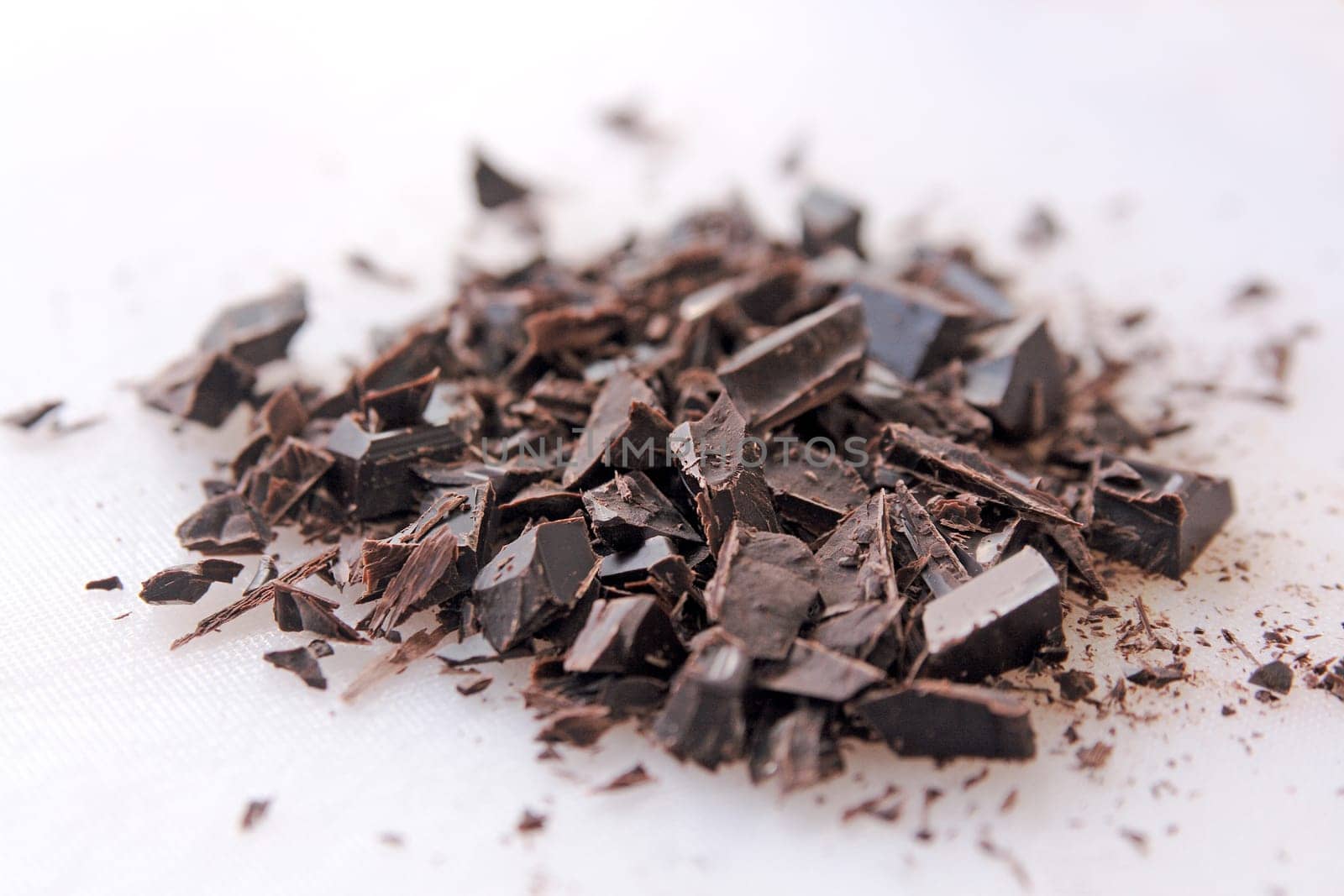 Dark chocolate pieces cut up on a white cutting board