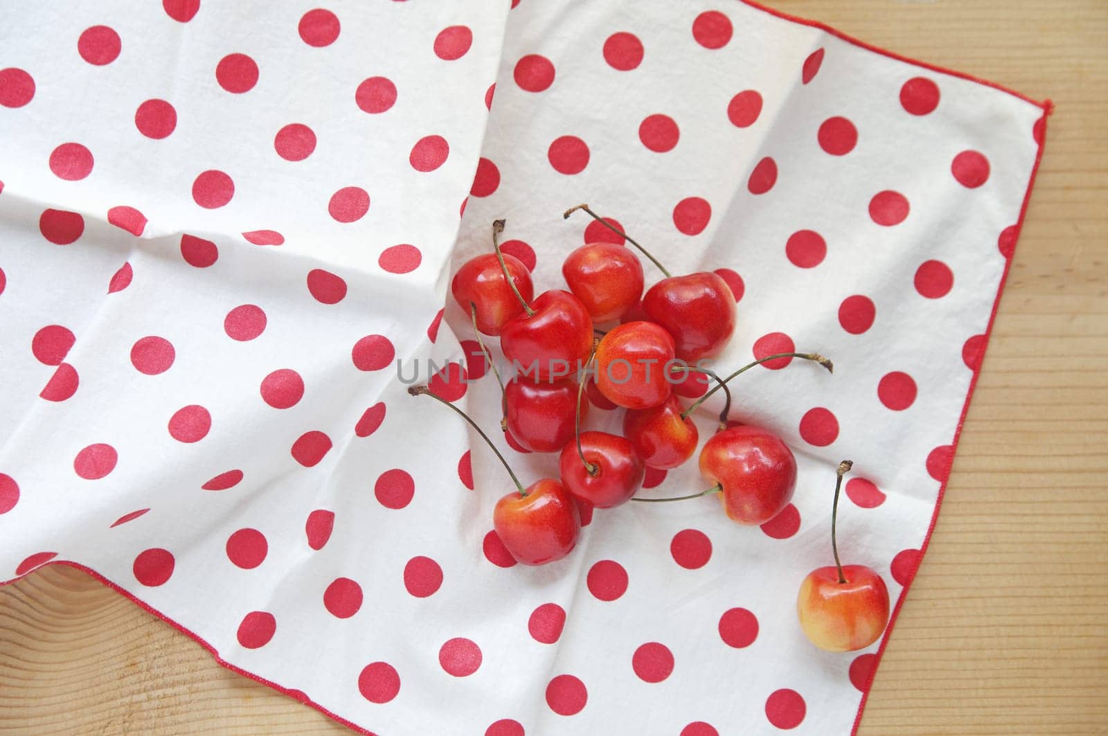 Fresh cherries on a white napkin with red polka dots