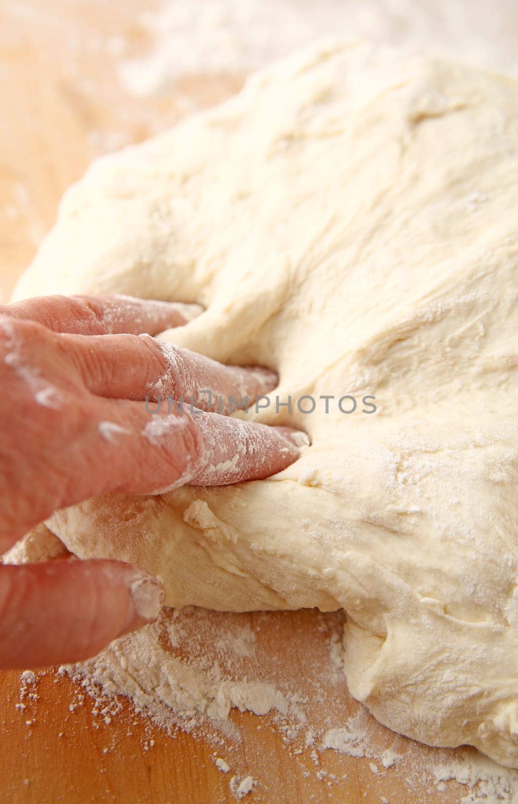 Fingers covered in flour and dough with bread dough