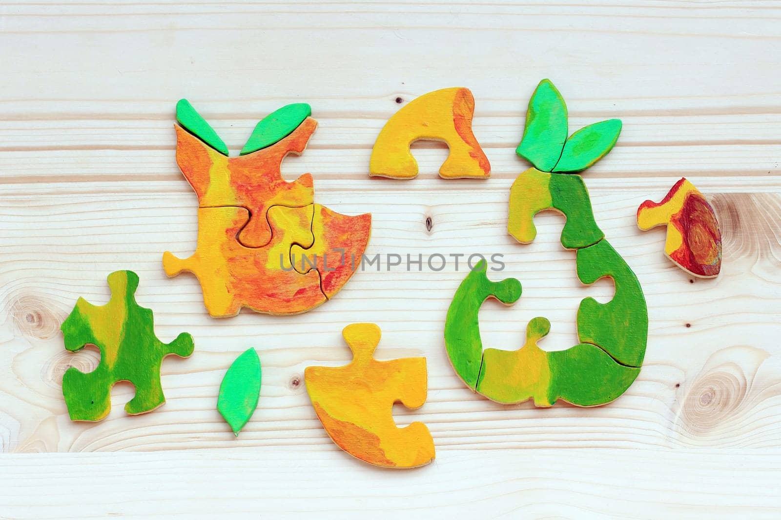 Two wooden puzzles made of colorful pieces. Colorful fruit as a puzzle is a beautiful children's toy