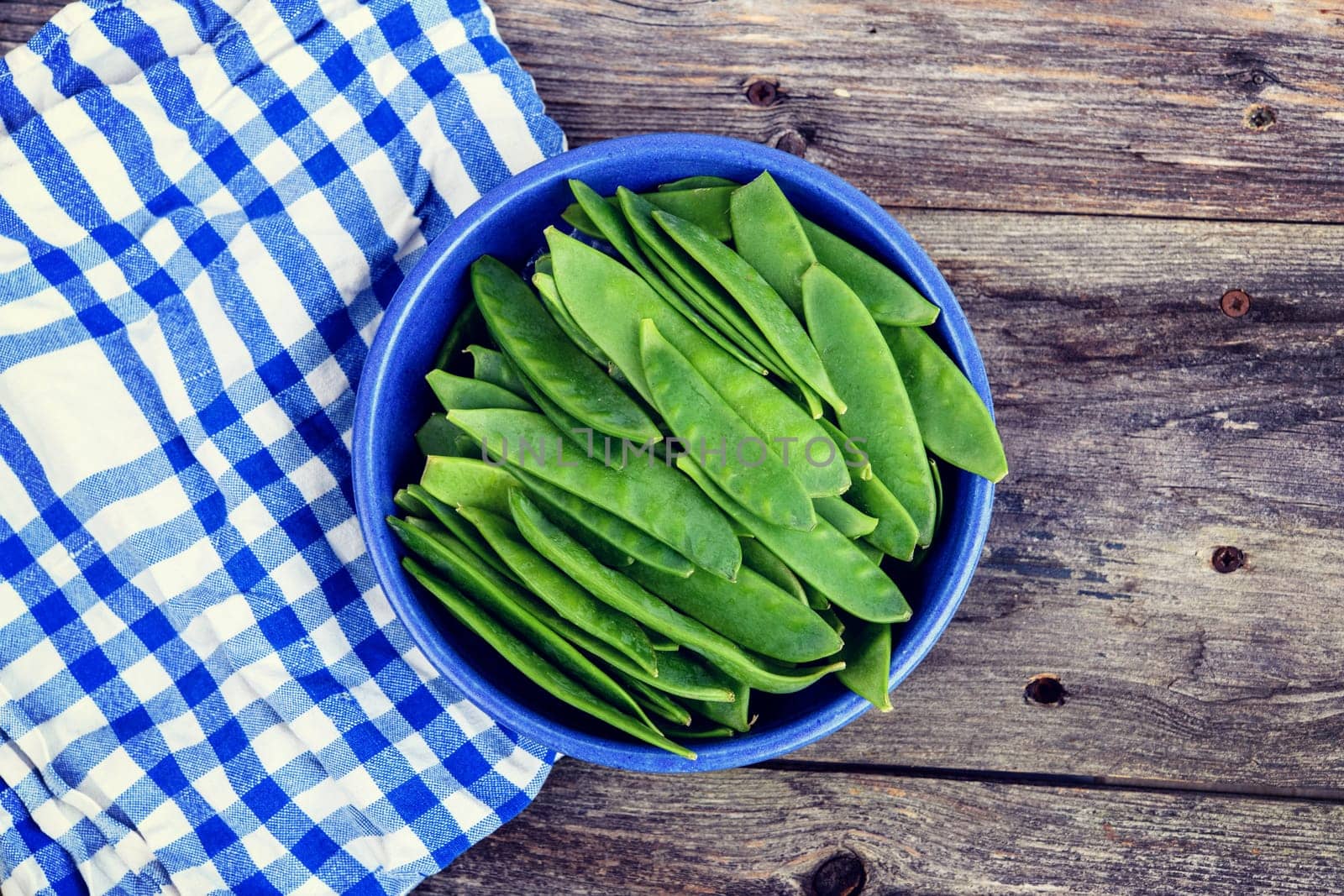 blue bowl with green peapods and towel