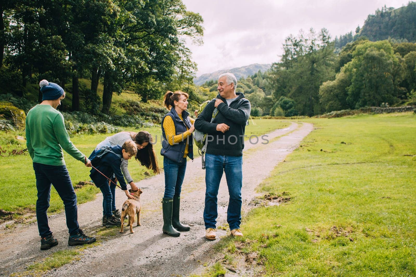 Three children are about to go for a hike with their grandparents and the dog.