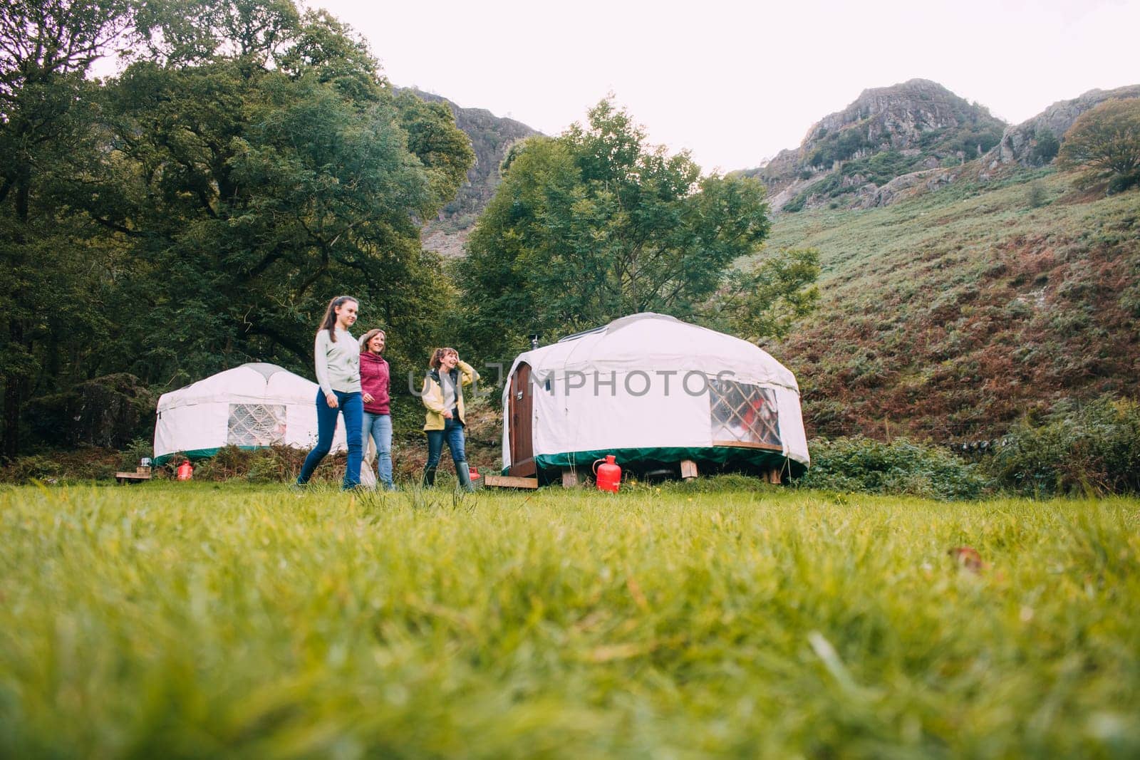Three generation family are returning back to their camping yurt after a long hike together.