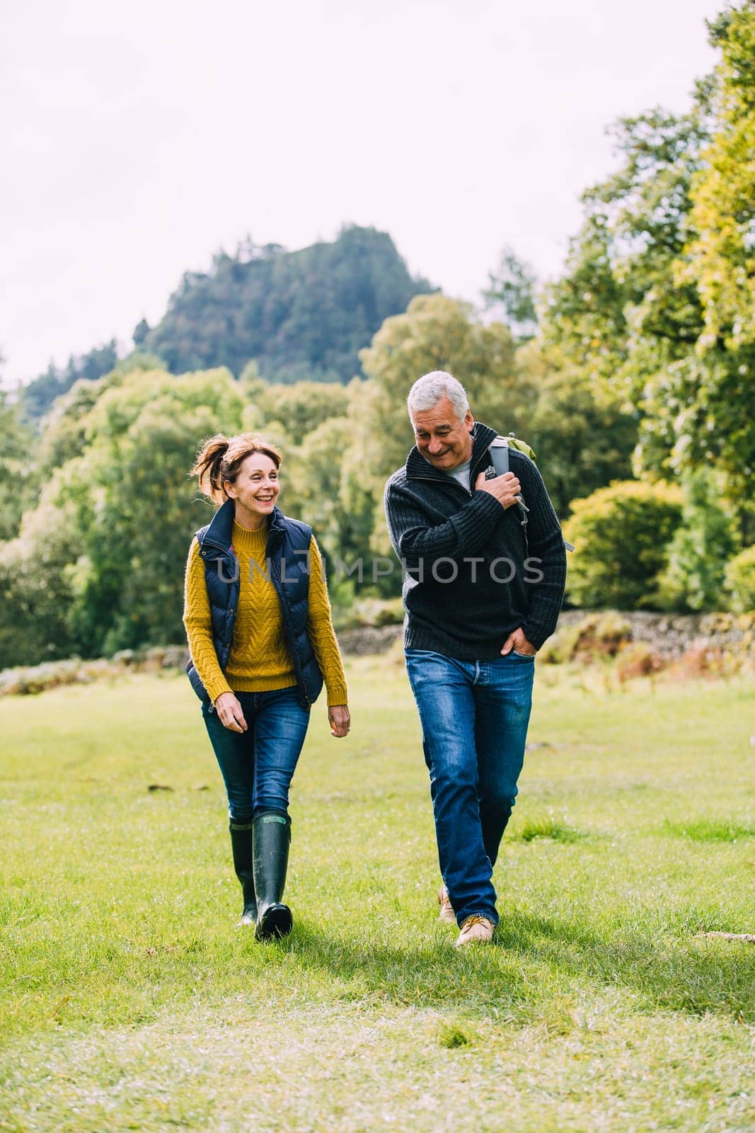 Senior couple are enjoying a walk through the woodlands at the Lake District