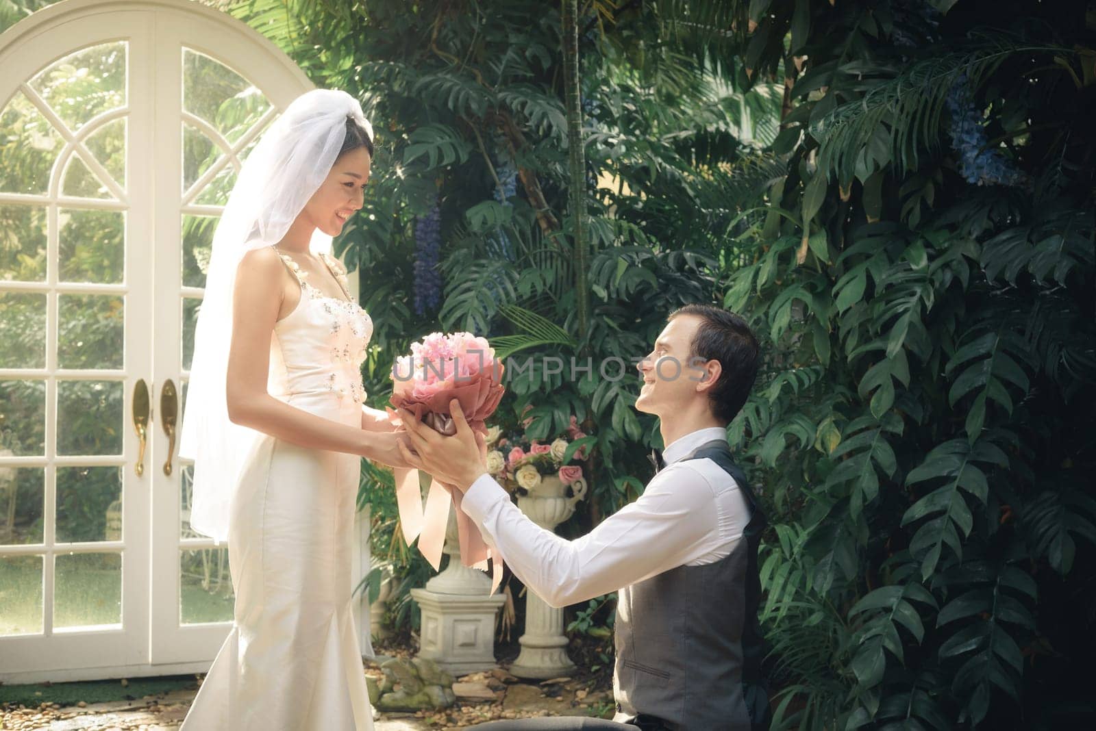 man stand on knee with flower make a proposal to get married to beautiful girlfriend, engagement concept