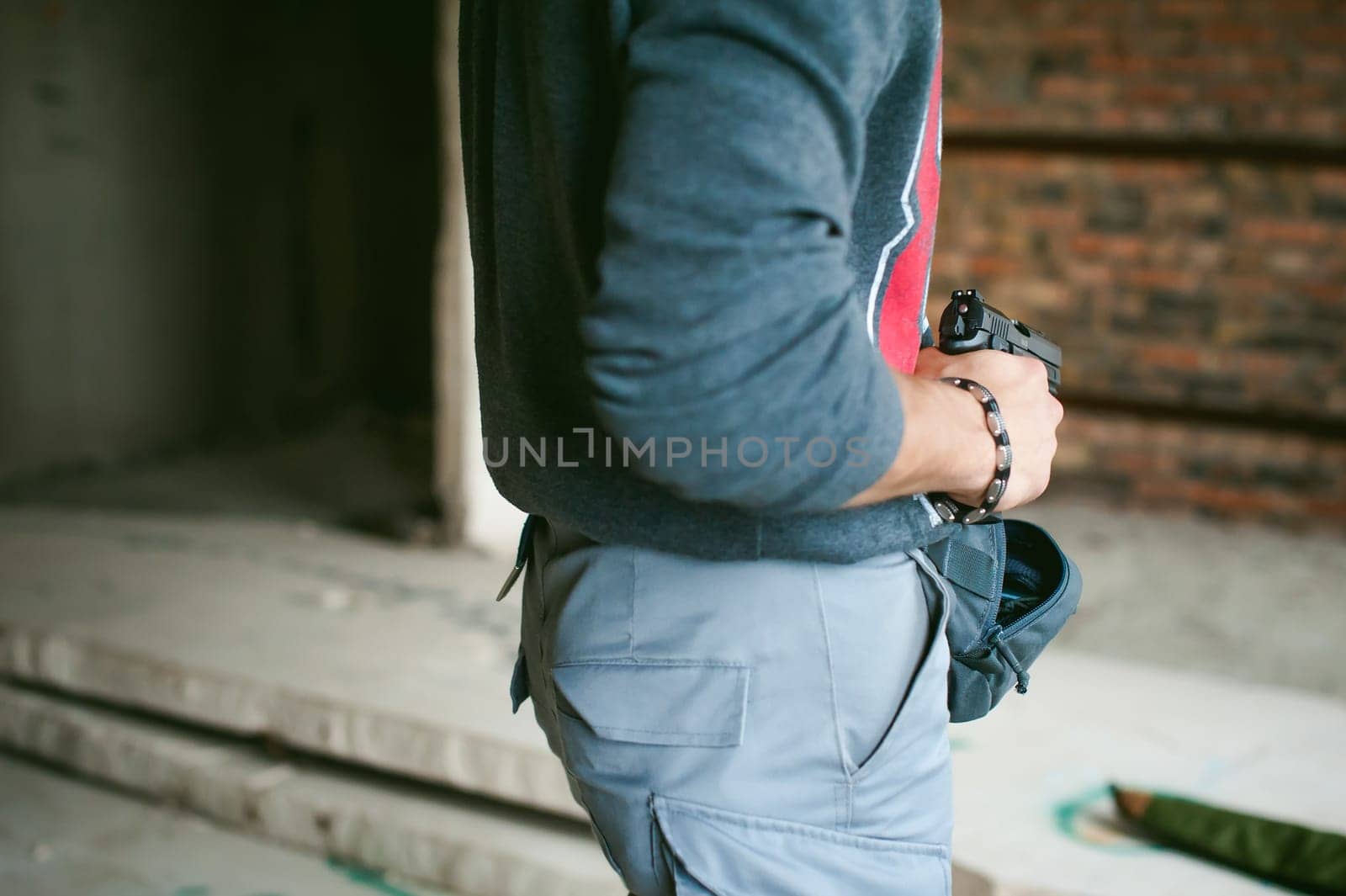 man pulls a gun out of his bag, holding it in his hand