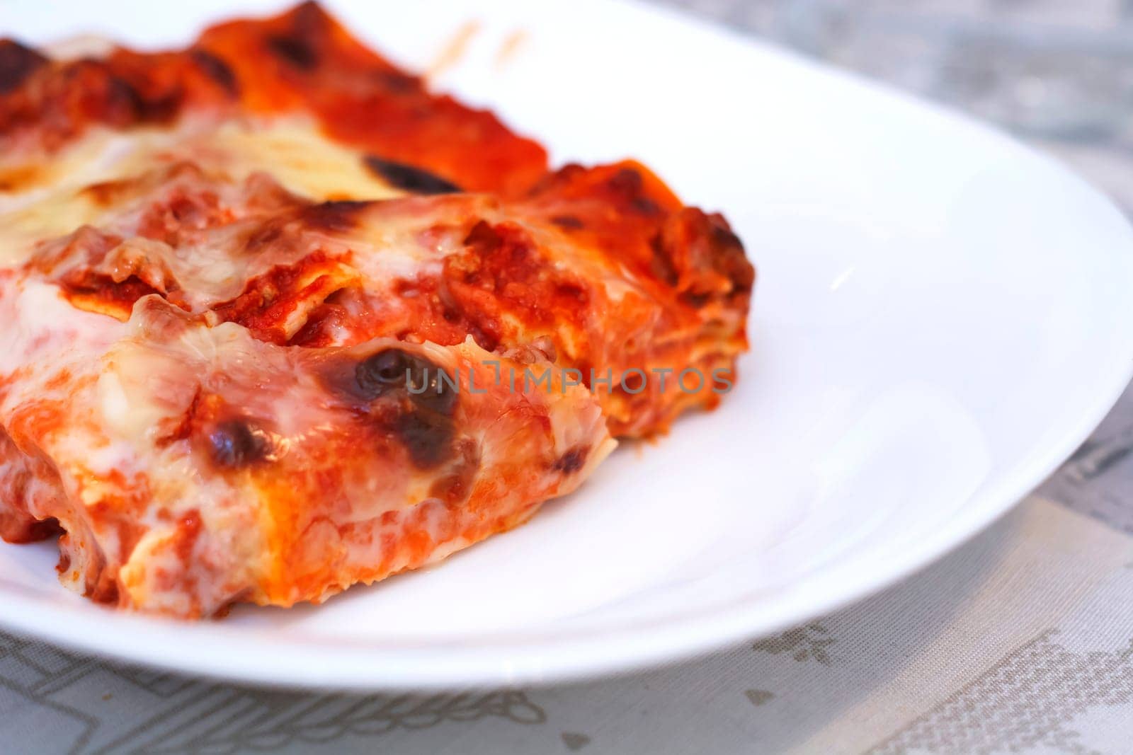 close-up view of a portion of lasagna served on a white plate