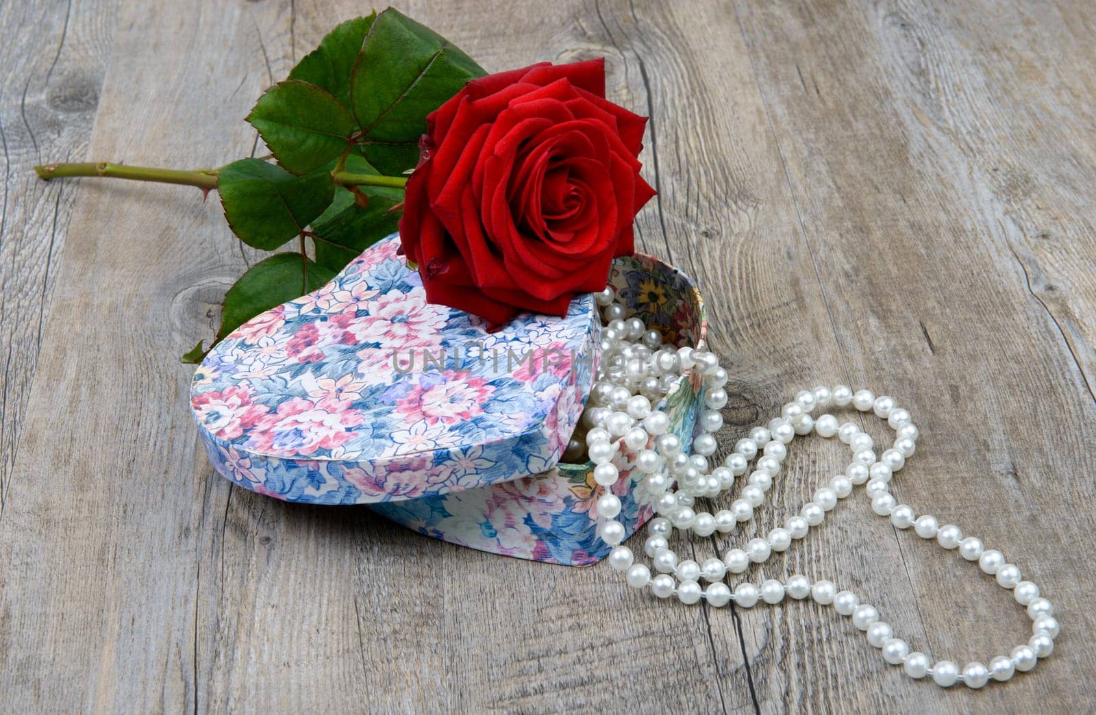 a rose and a gift for Valentine's Day on the wooden table