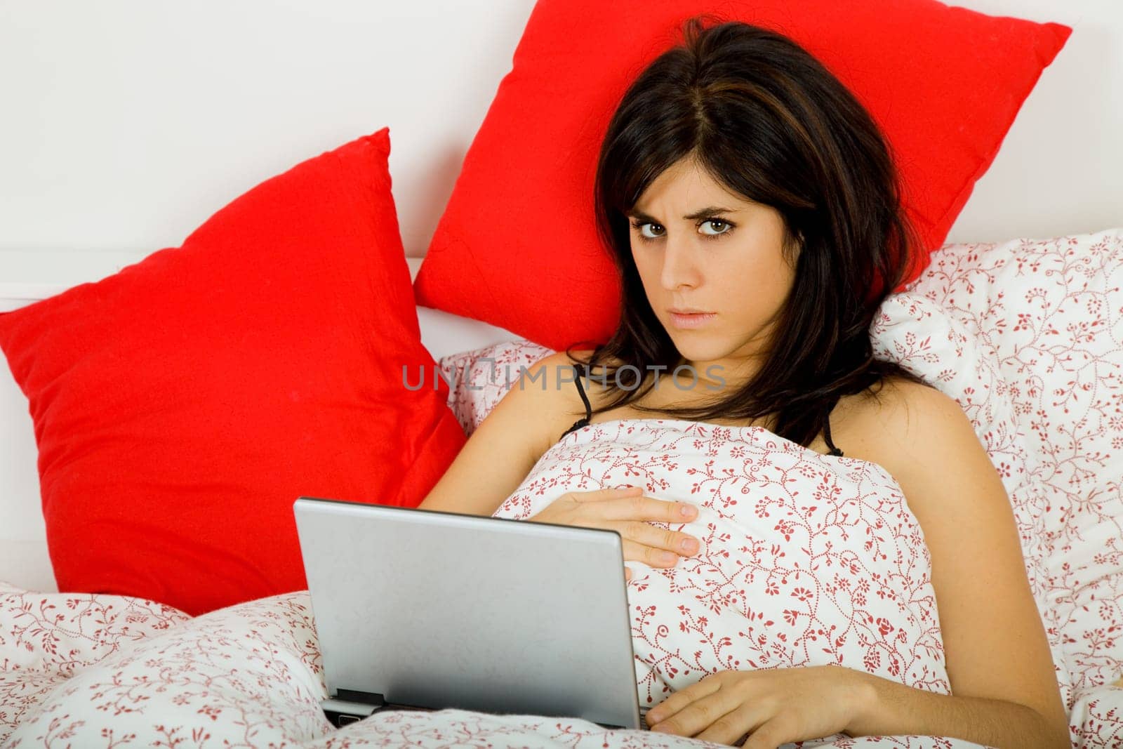 young beautiful woman working with laptop in bed