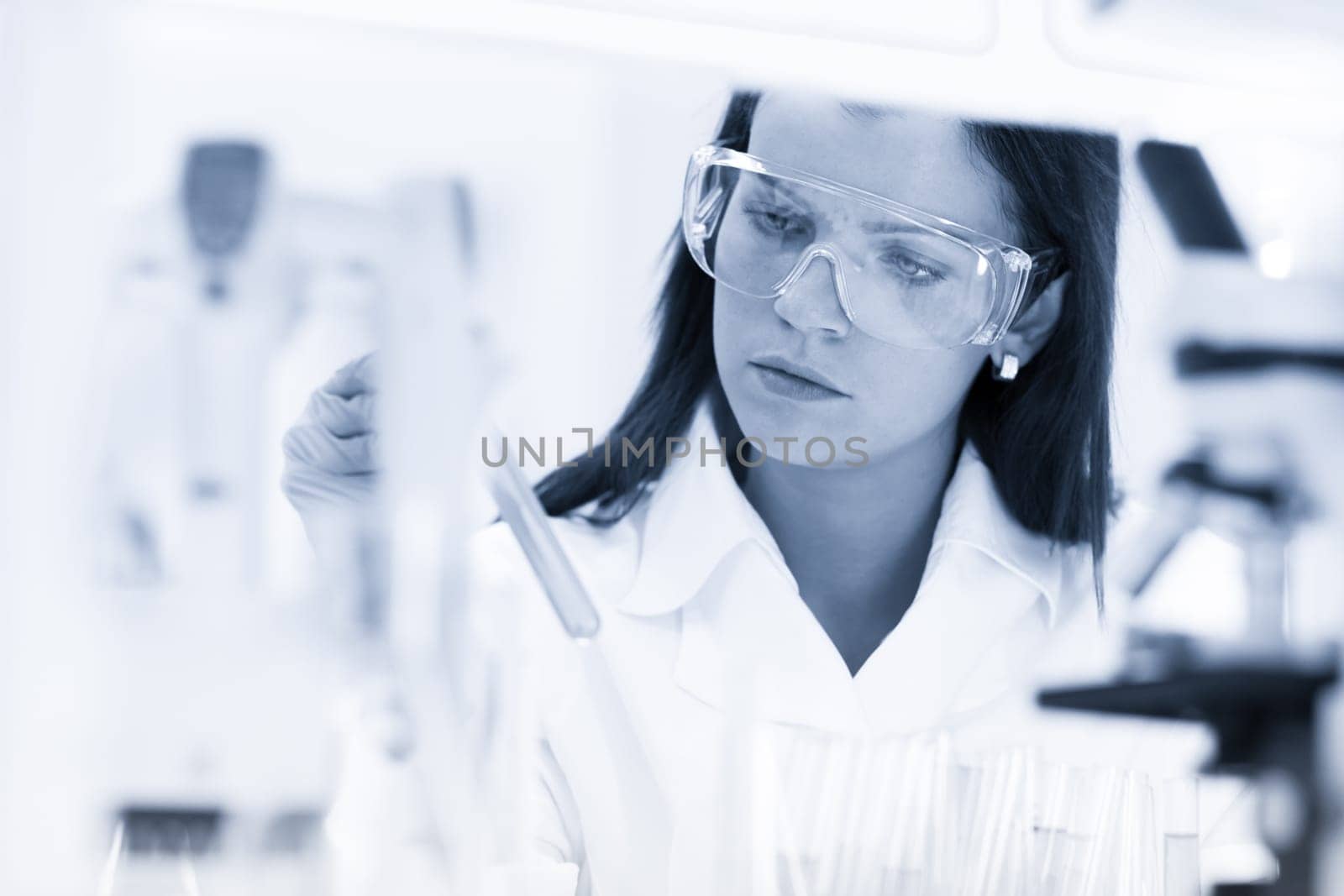 Scientists researching in scientific laboratory. Young female young PhD student scientist researching in the life science research laboratory. Biochemistry, genetics, forensics, microbiology ..