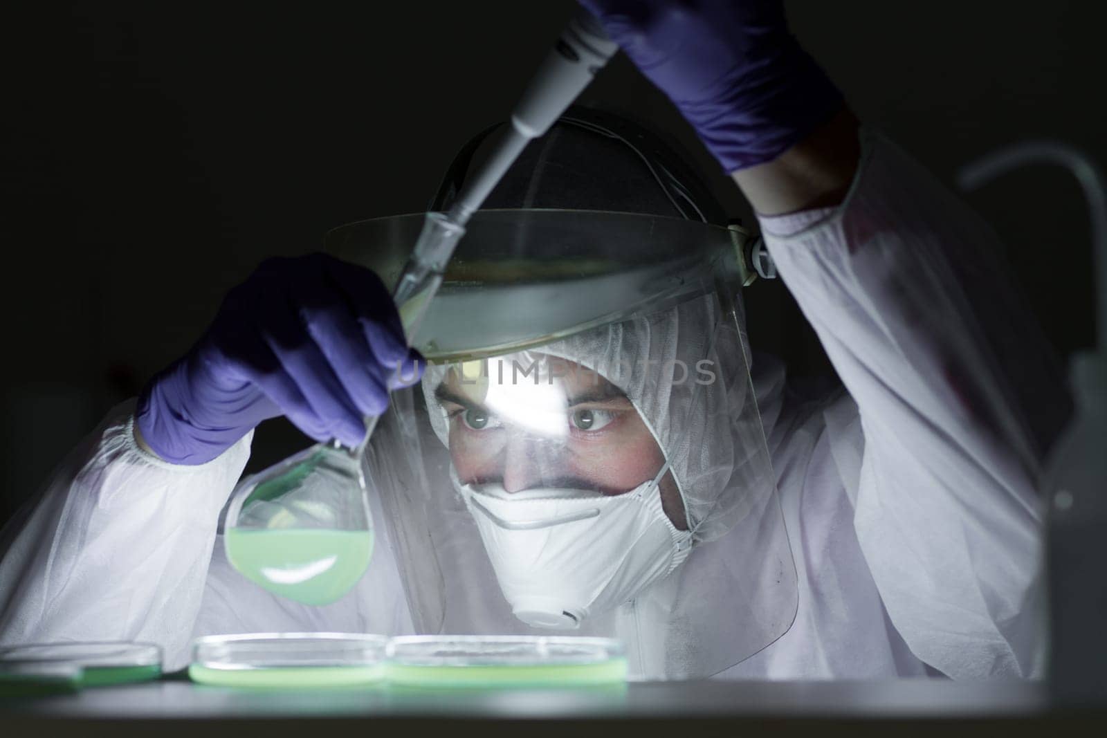 Life scientist researching in bio hazard laboratory. Focused life science professional working on experiment in high protection degree work laboratory. Healthcare and biotechnology.