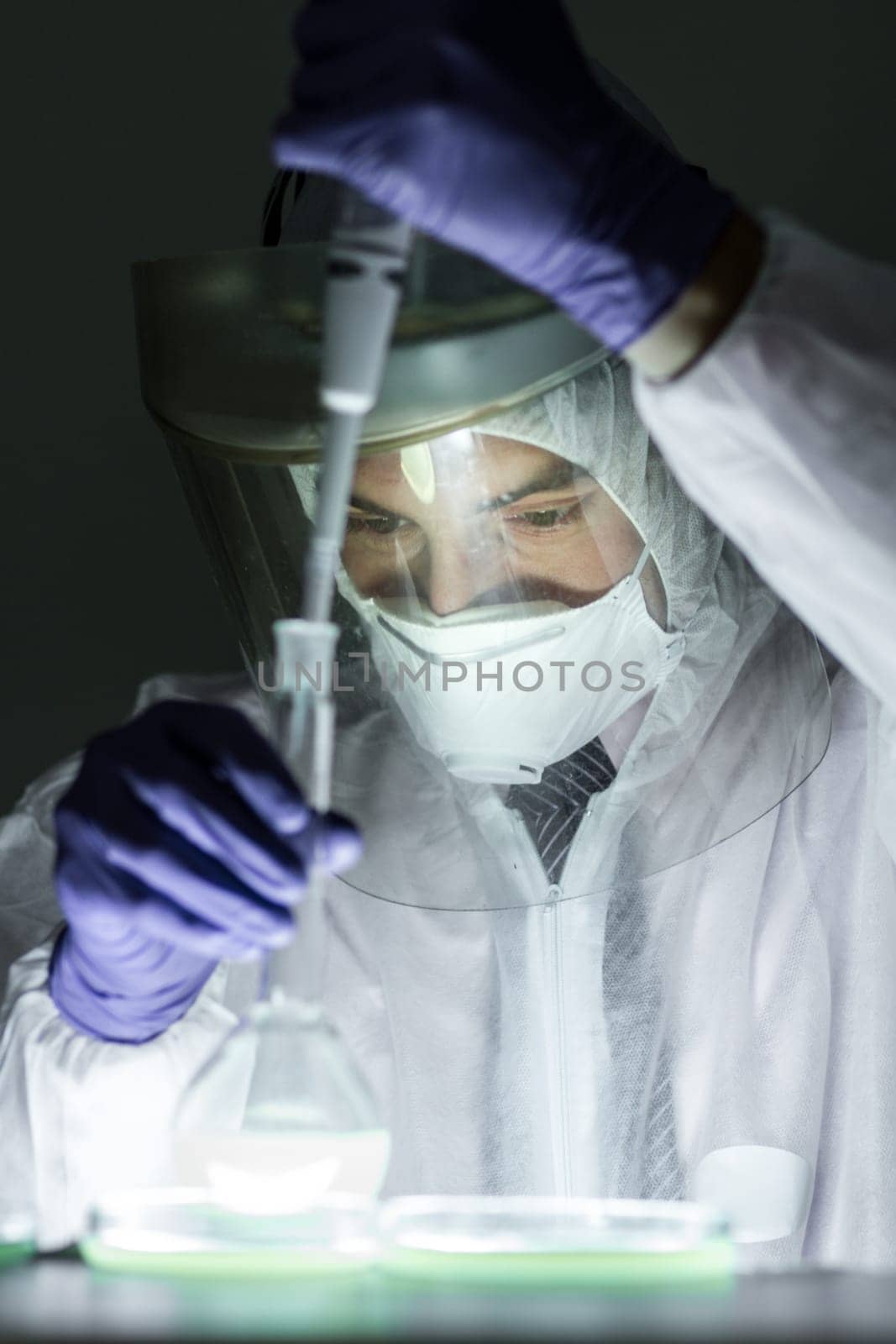 Life scientist researching in bio hazard laboratory. Focused life science professional working on experiment in high protection degree work laboratory. Healthcare and biotechnology.