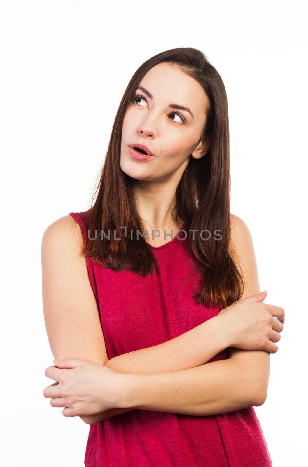 Pretty young woman looking up at copy space, on white background