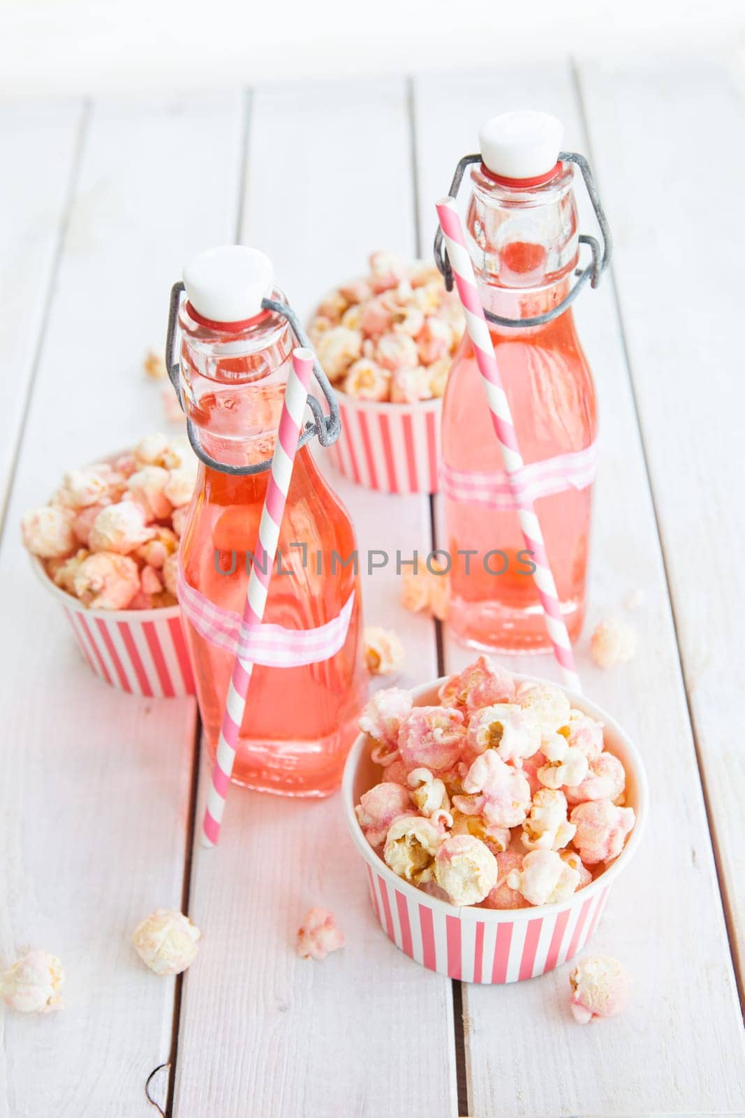 Colorful popcorn in striped cups and lemonade in small faschen