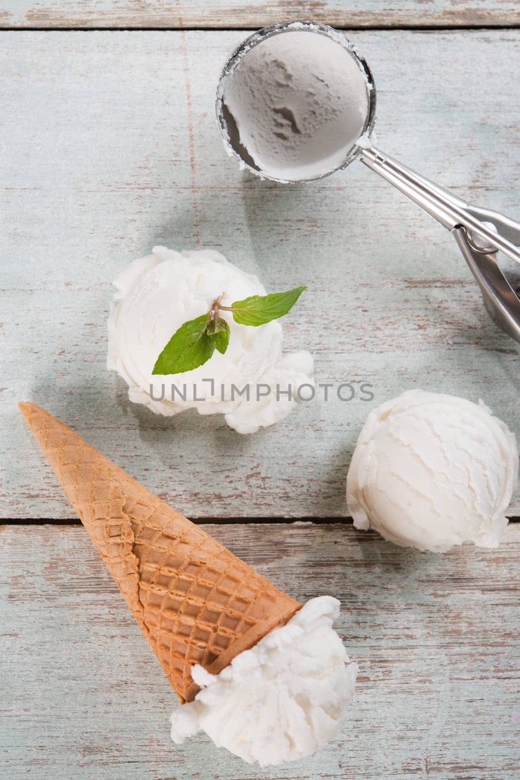 Top view coconut ice cream wafer cone on white rustic wooden background.