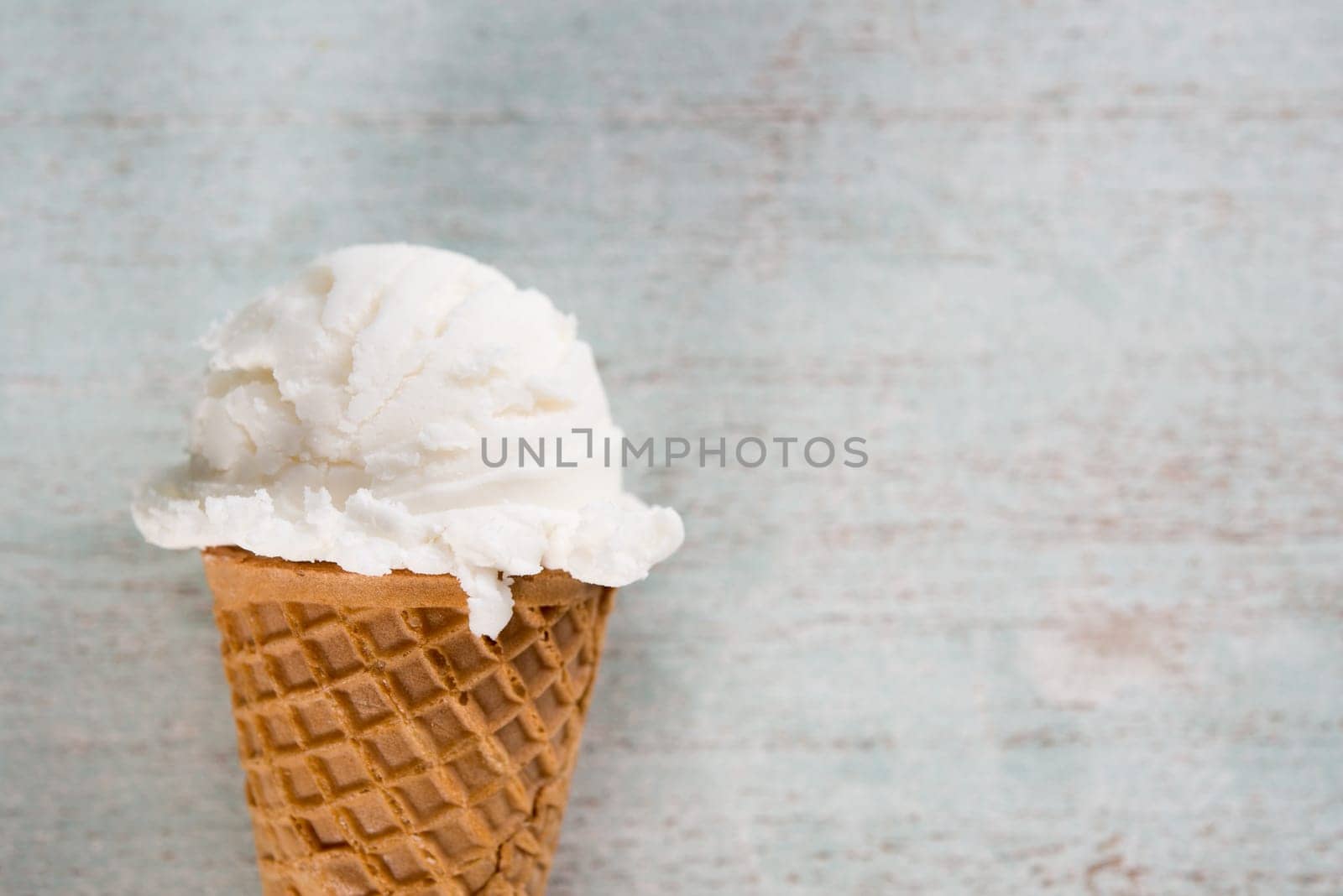 Top view yogurt ice cream wafer cone on white rustic wooden background. Copy space on side.