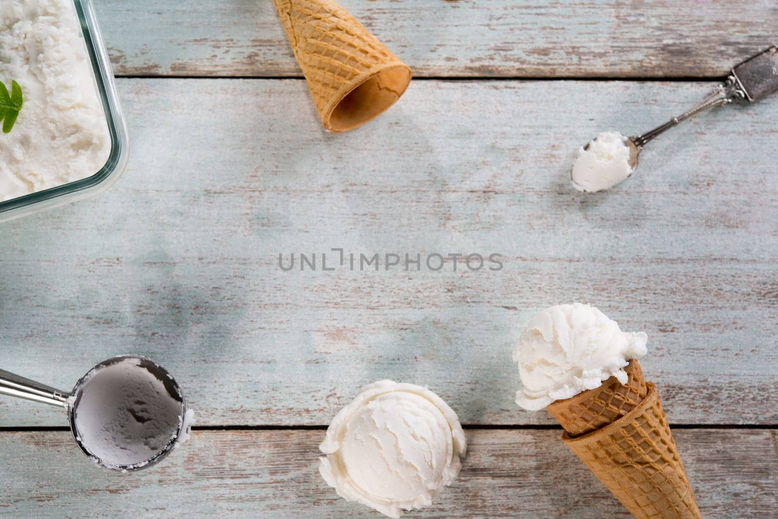 Top view vanilla ice cream wafer cone on white rustic wooden background. Copy space in middle.