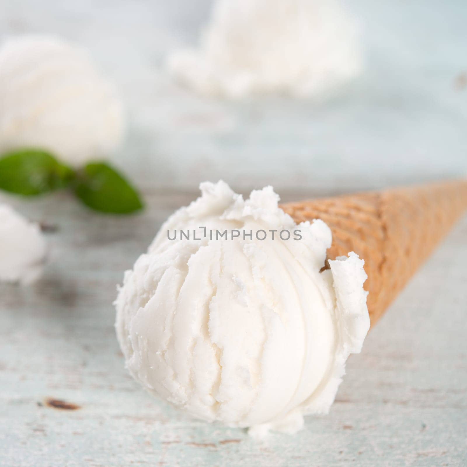 Milk ice cream wafer cone on white rustic wooden background