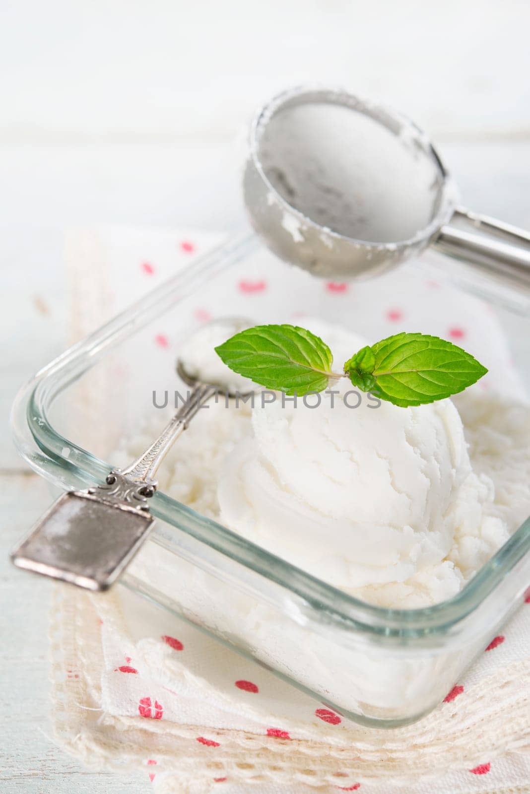 Coconut ice cream in bowl on white wooden background.